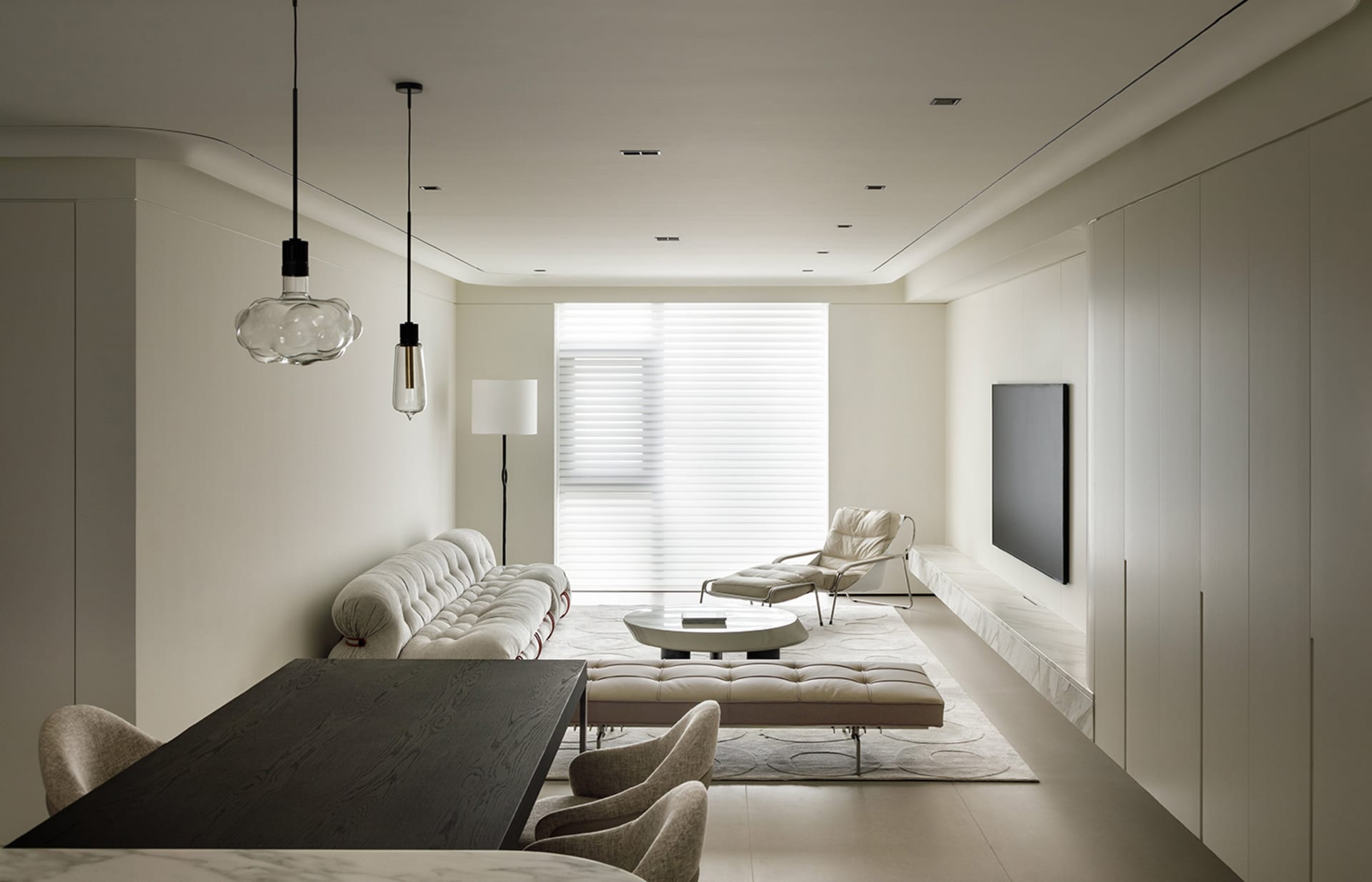 A modern living room with neutral-colored furniture, a large window, and minimalist decor.