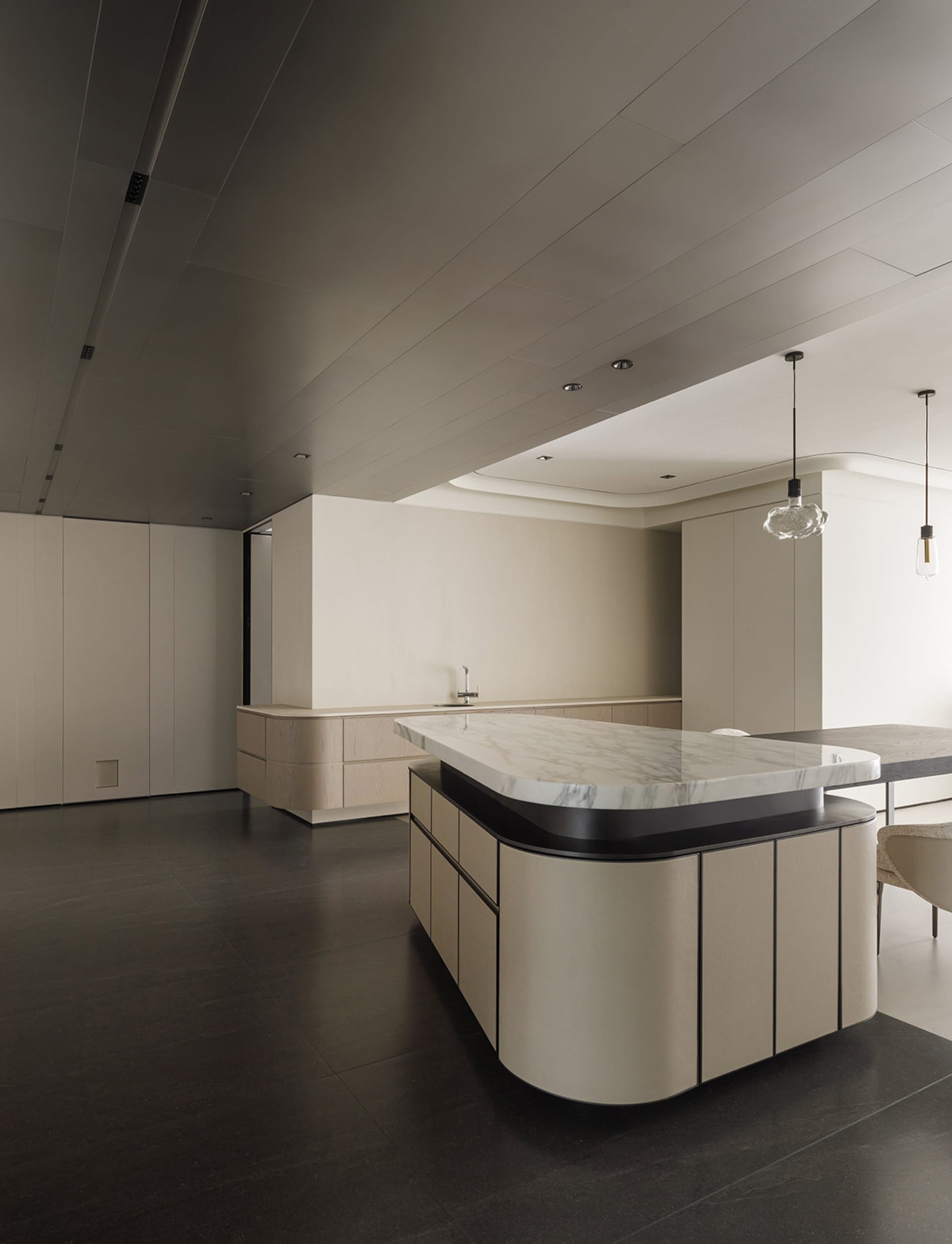 Modern kitchen featuring marble countertops and light wood cabinets