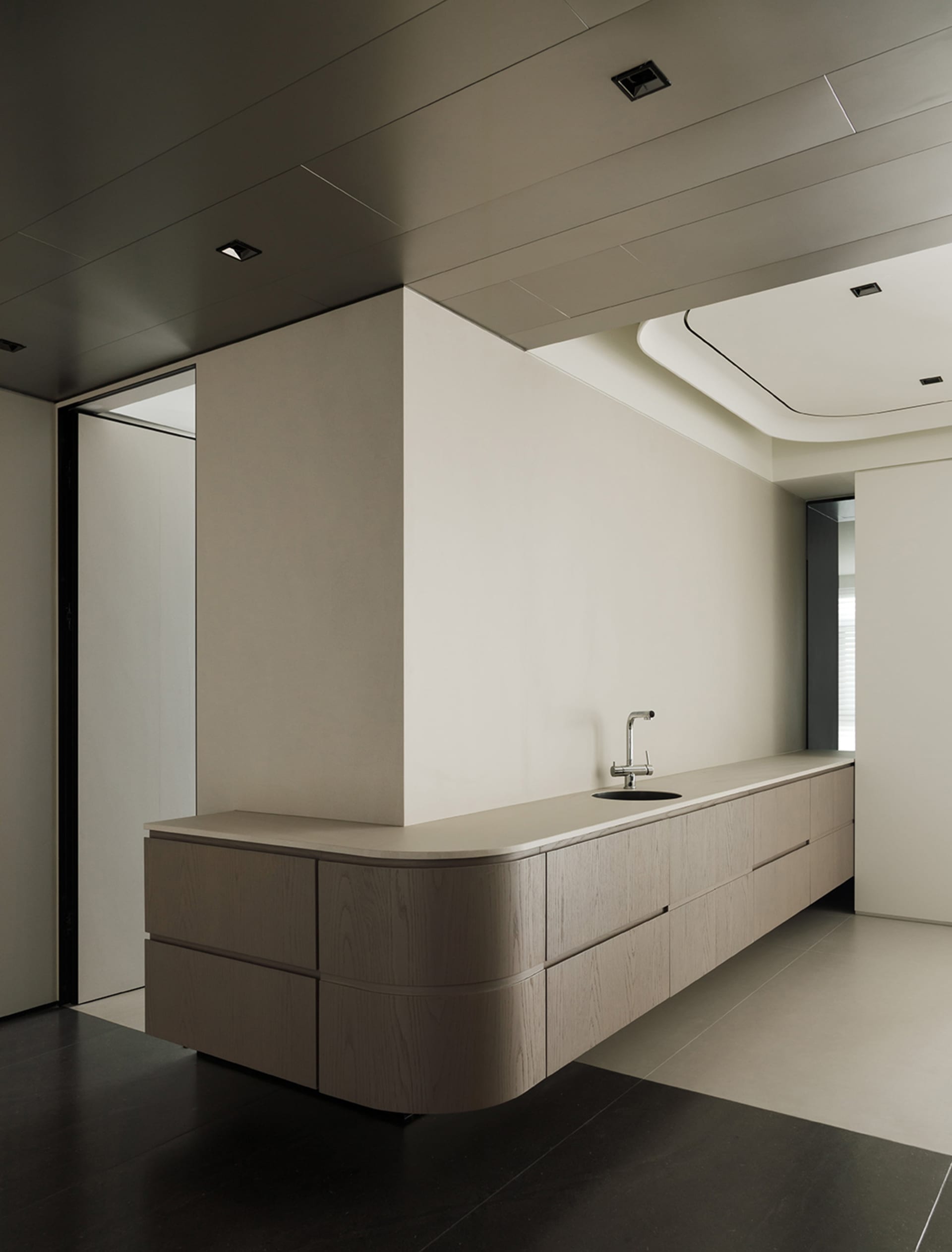 Modern residential interior with minimalist design featuring floating wood cabinets.