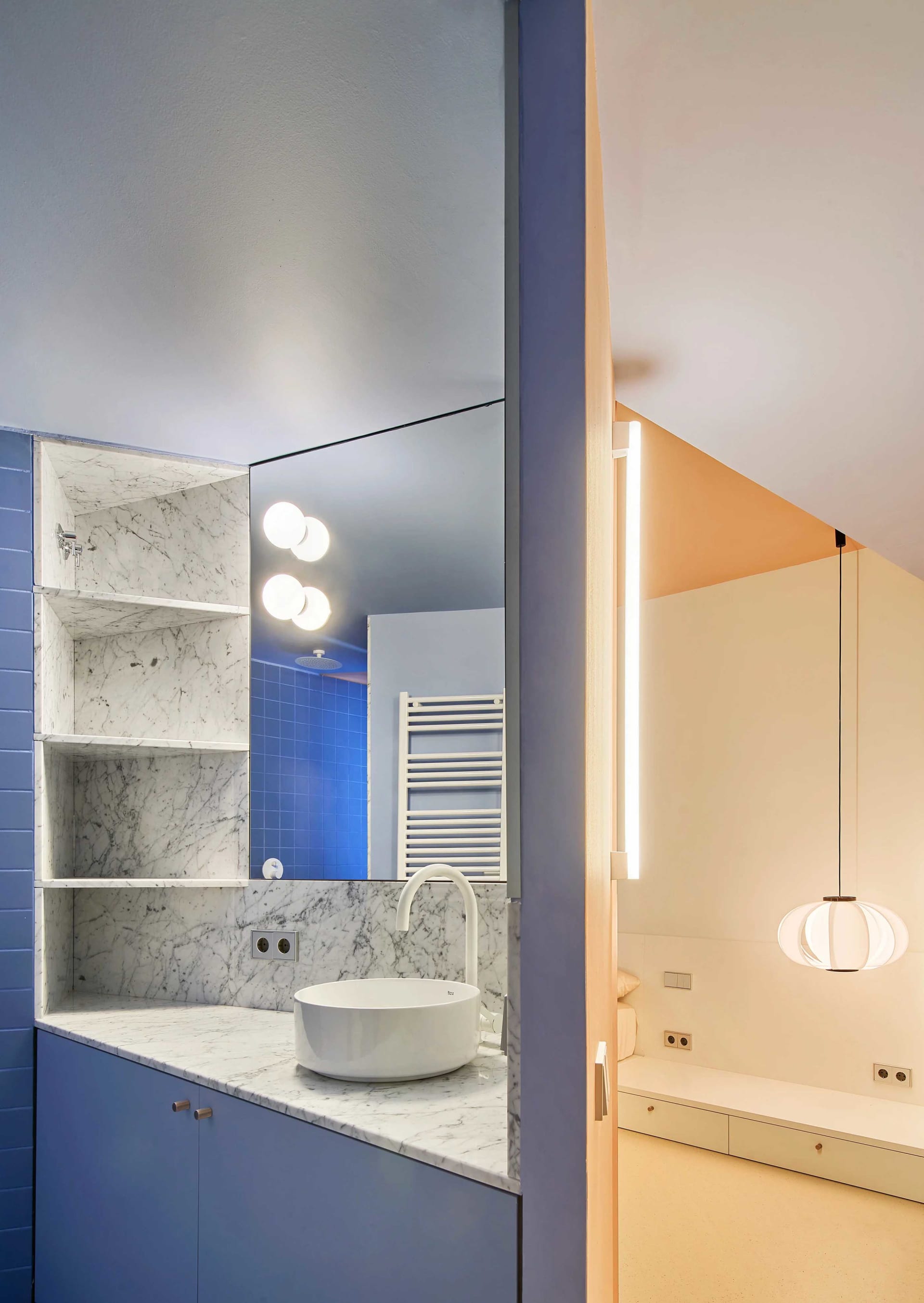 Modern minimalist bathroom with blue marble walls and white porcelain sink.