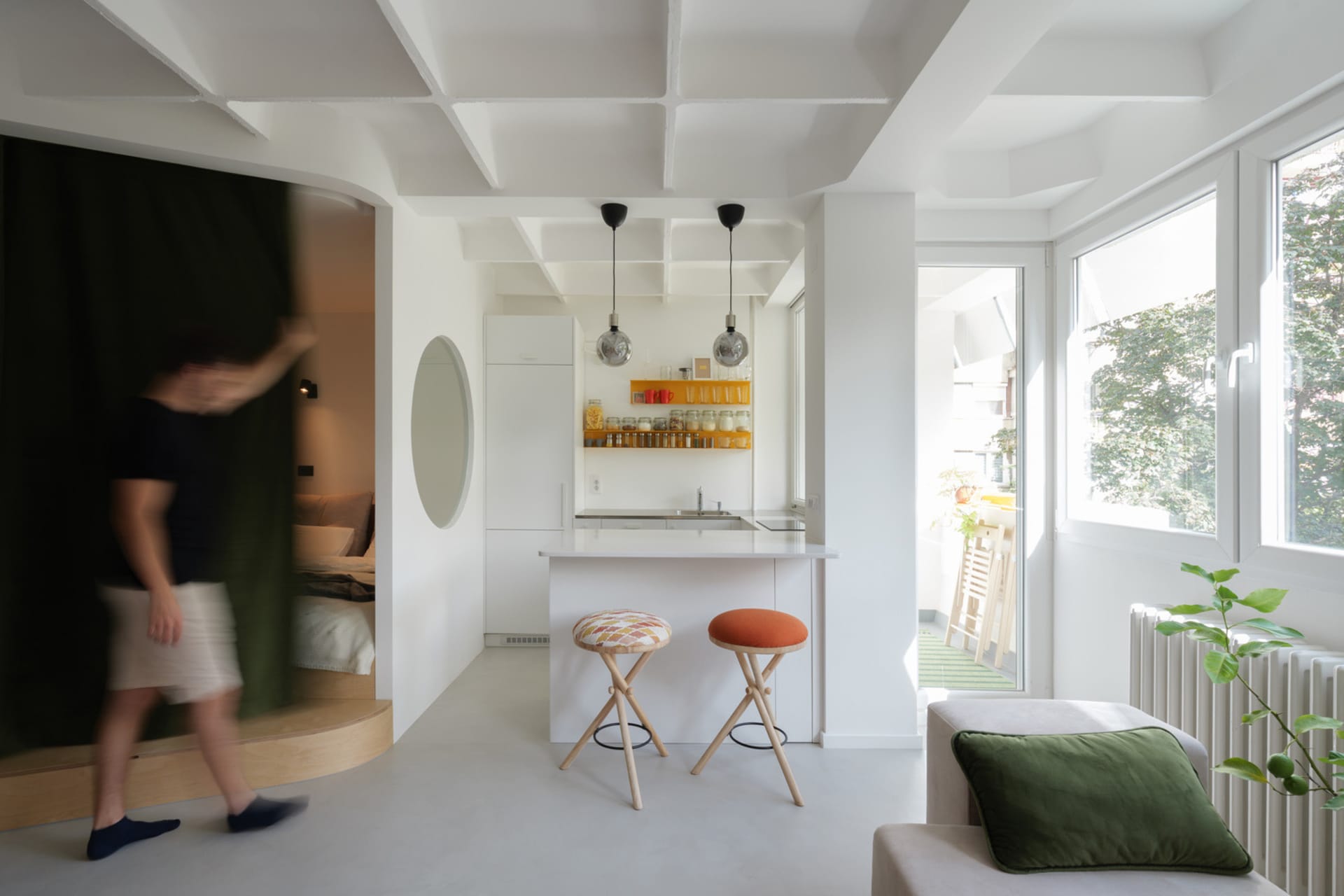 A modern, minimalist kitchen with white surfaces and an open-plan design.