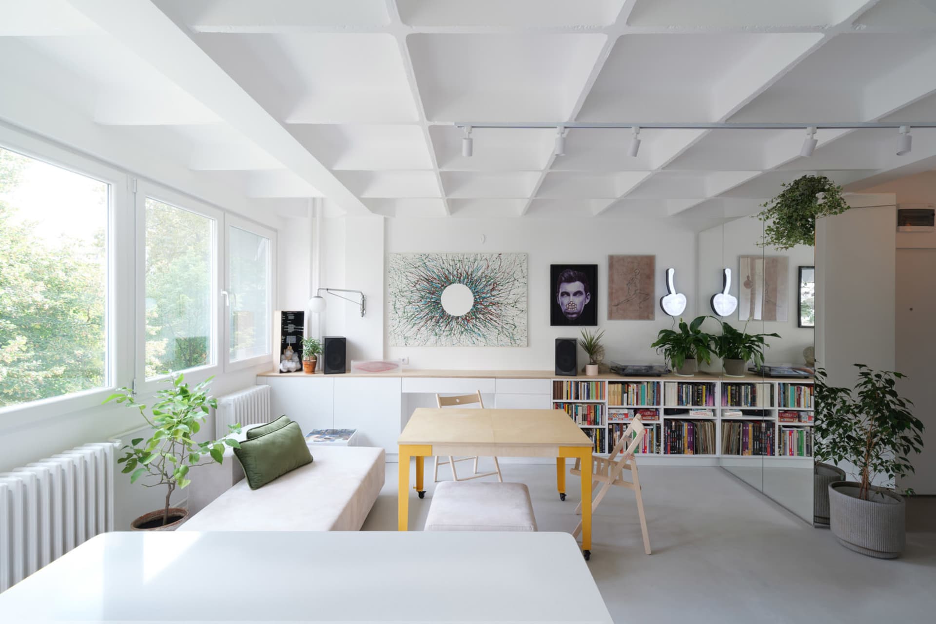 A modern minimalist living room with a bamboo table and painted wooden floor.