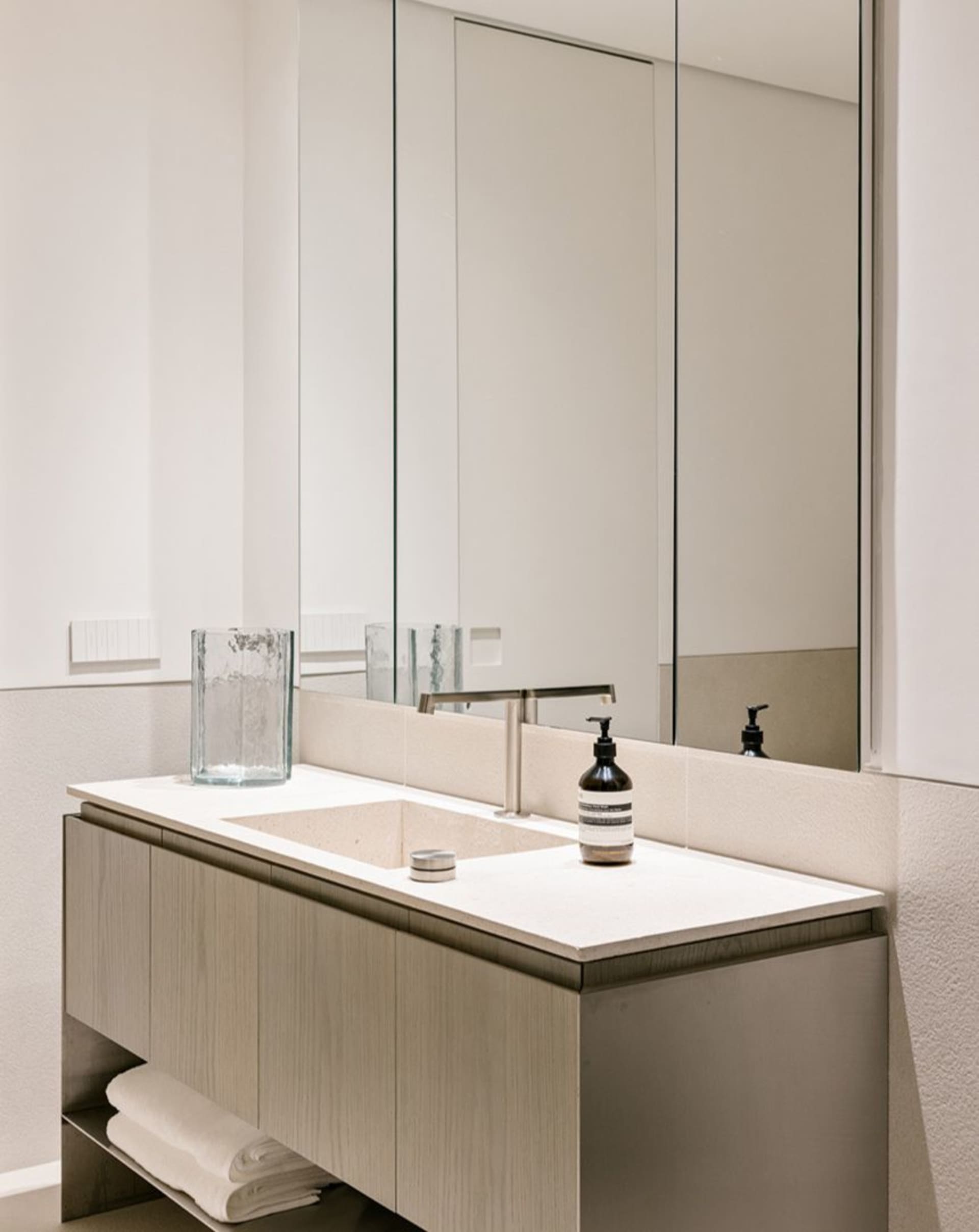 Minimalist bathroom with a modern, sleek design featuring marble surfaces.