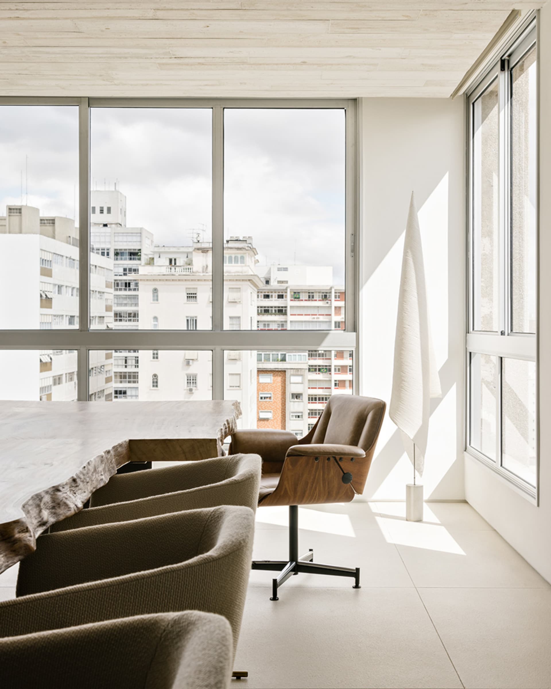 A modern minimalist living room with concrete furniture and white painted walls.