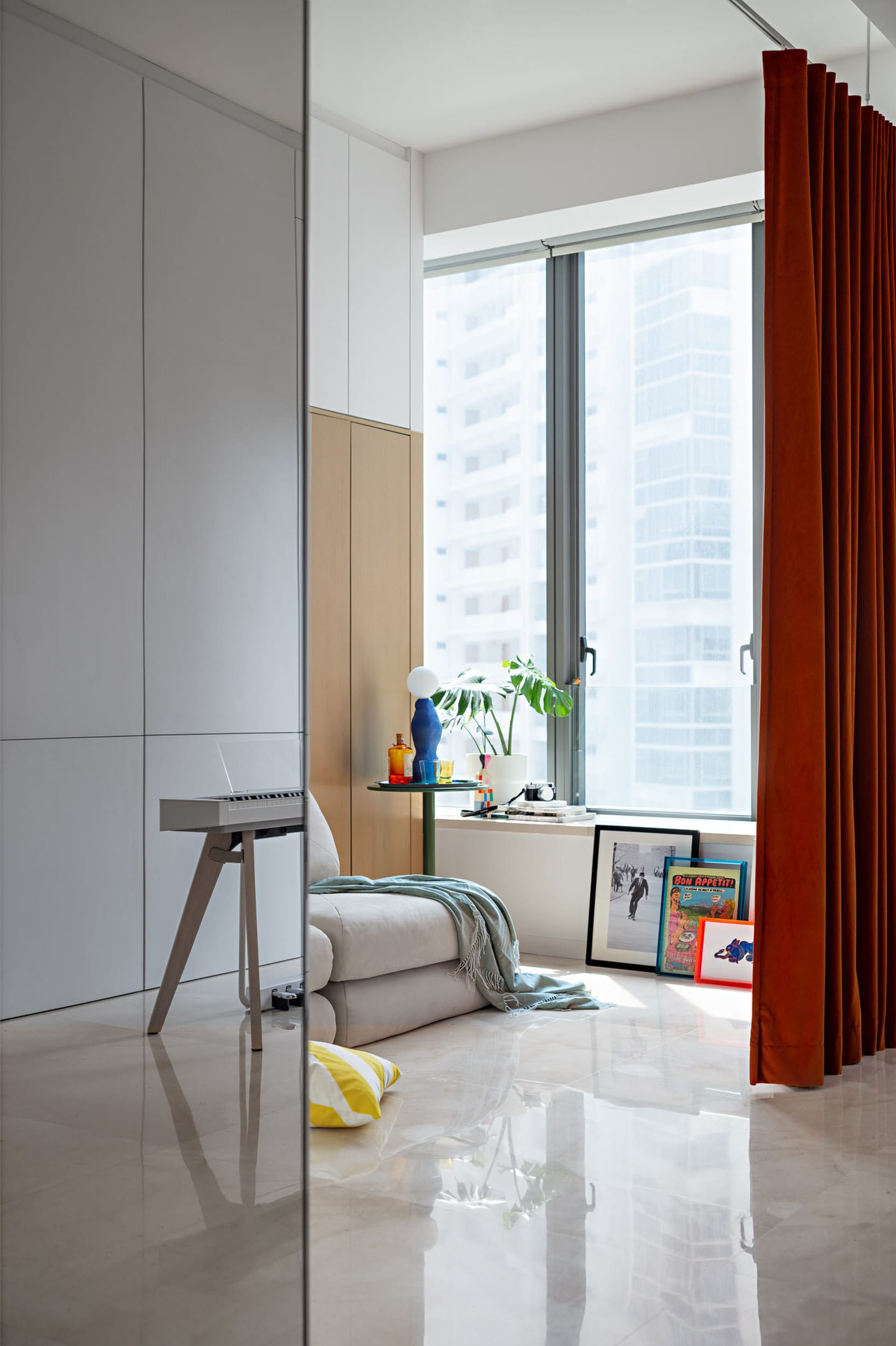 A modern living room featuring a marble floor and paneled cabinetry.