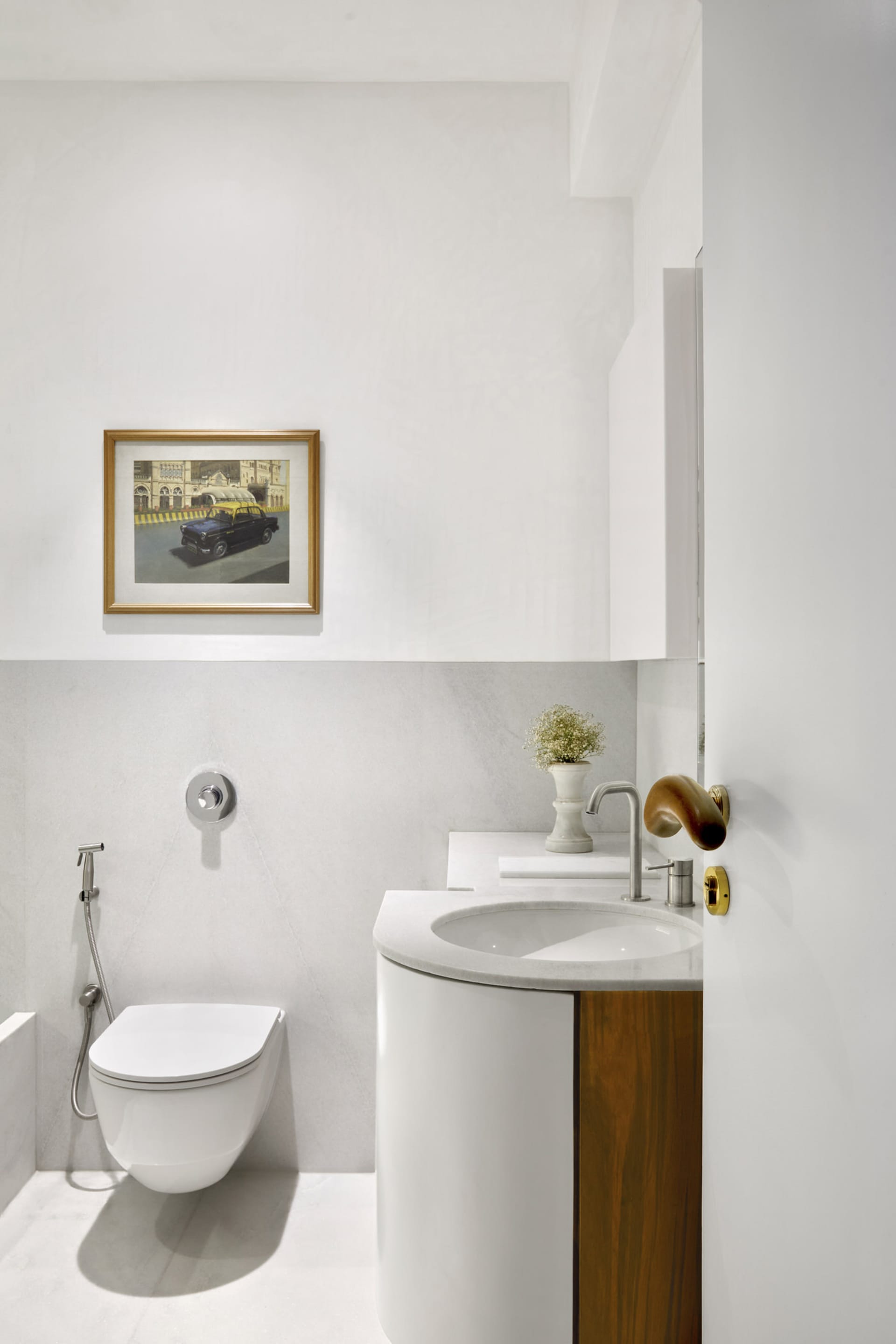 Modern bathroom with white marble sink, toilet, and wall art