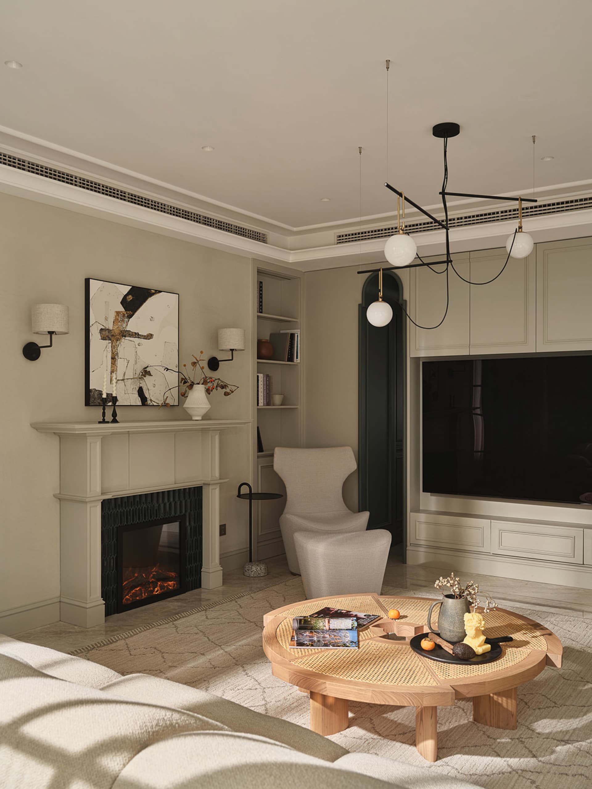 A modern living room featuring a fireplace, round rattan coffee table, and minimalist furniture on a ceramic floor.