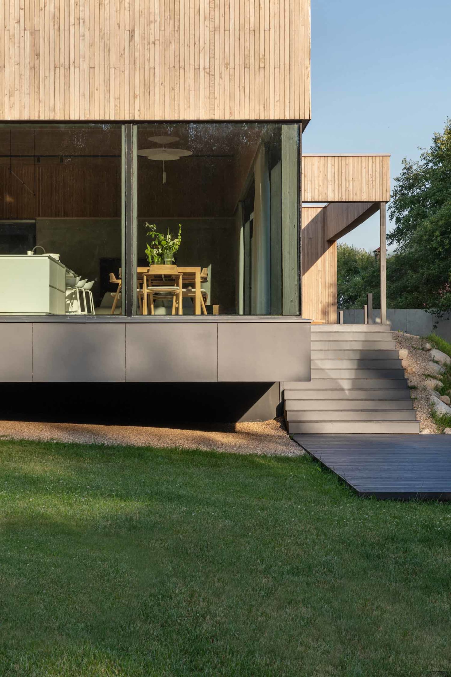 A modern residential building featuring a wooden exterior and glass windows.
