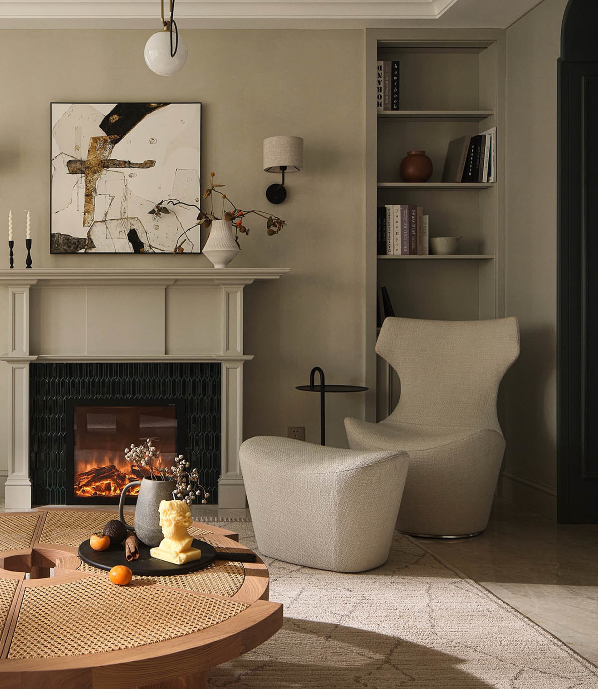 A cozy living room featuring neutral-toned fabric furniture and wooden accents, with a fireplace and bookshelf in the backgro