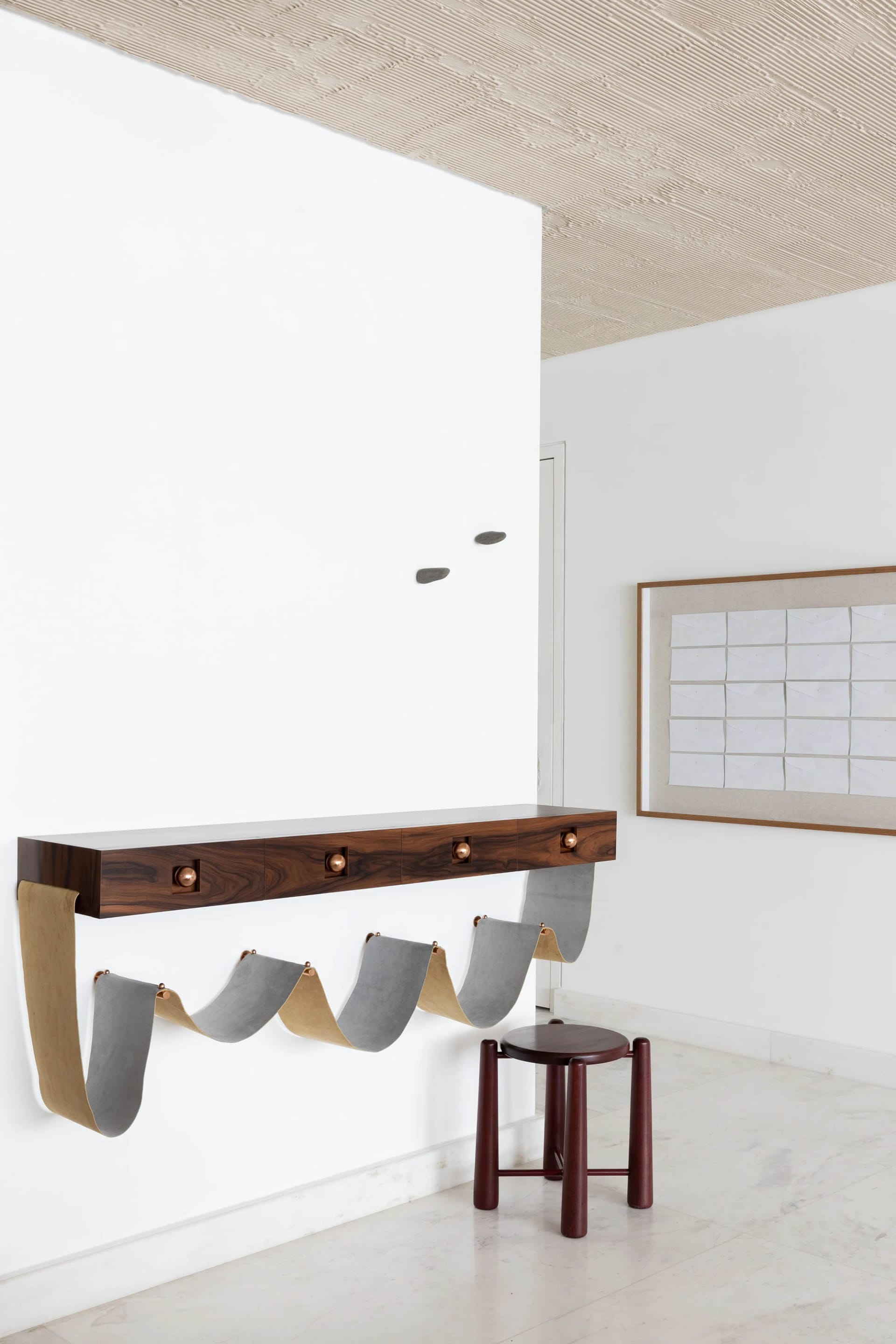 Modern minimalist entryway featuring metal and leather furniture.