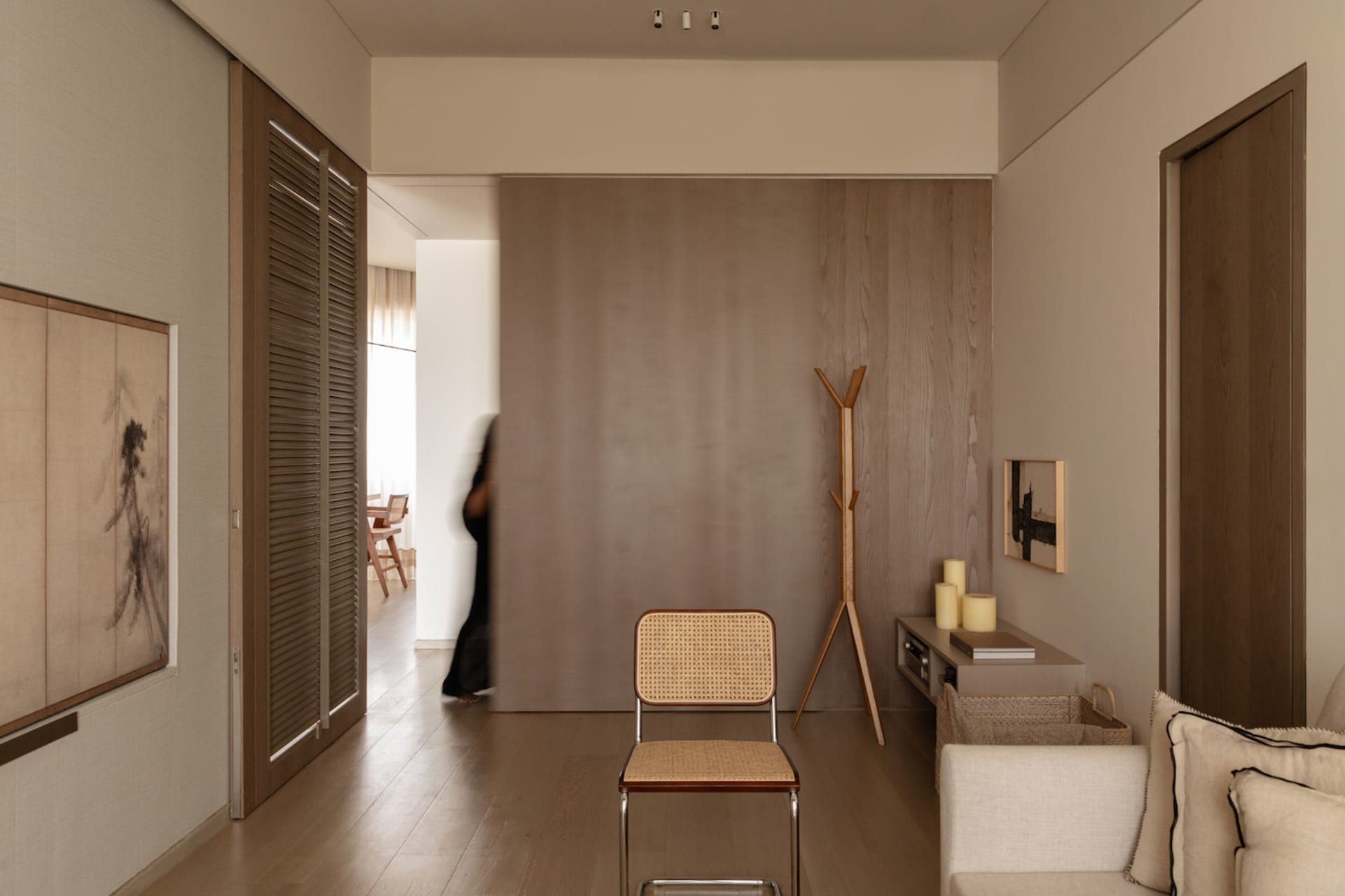A minimalist living room featuring wooden furniture and textured fabric accents.