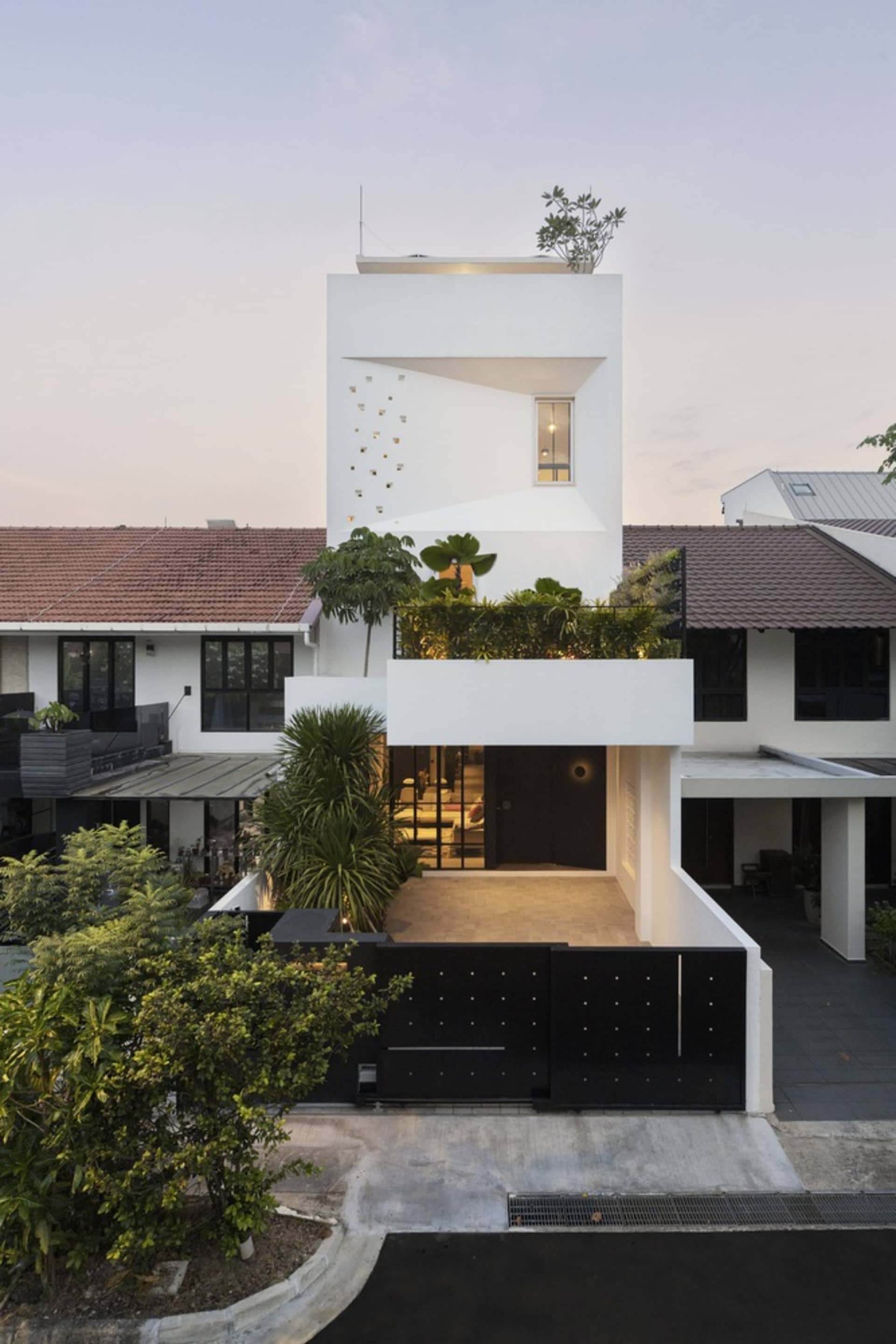 White-rendered exterior of a modern house with a garden.