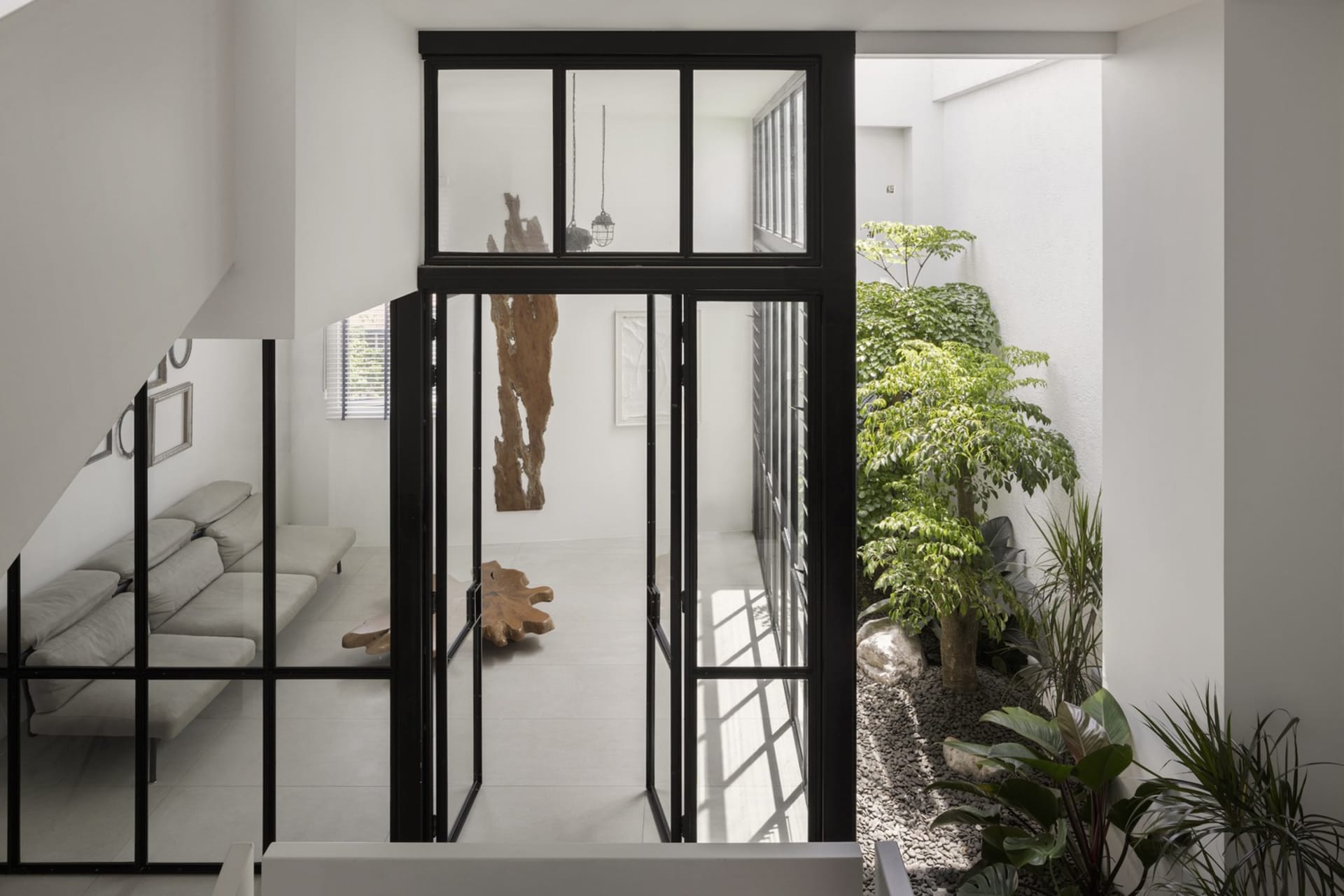 A modern living room with transparent glass windows, showcasing a minimalist design.