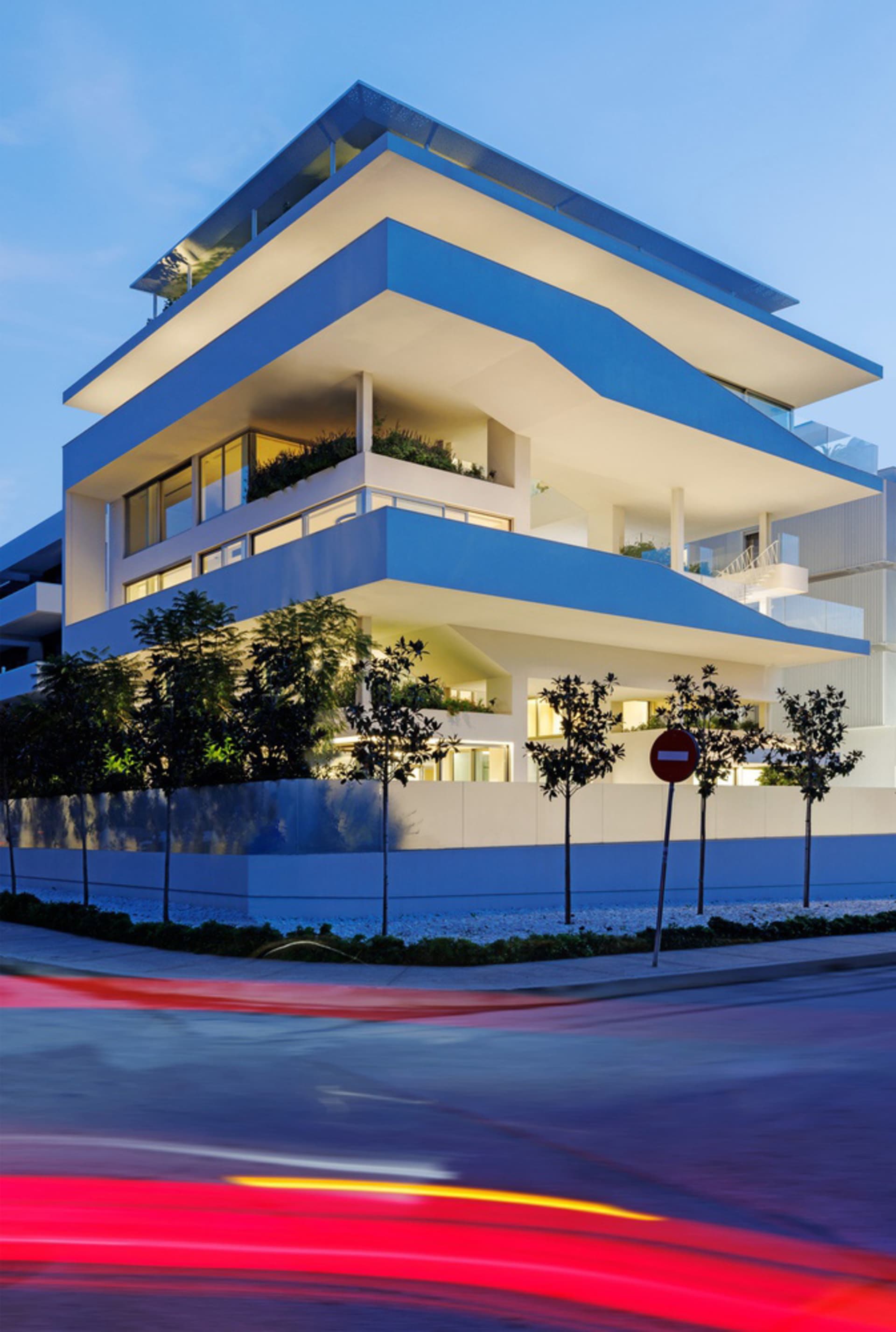 A modern apartment building constructed with concrete and glass materials.