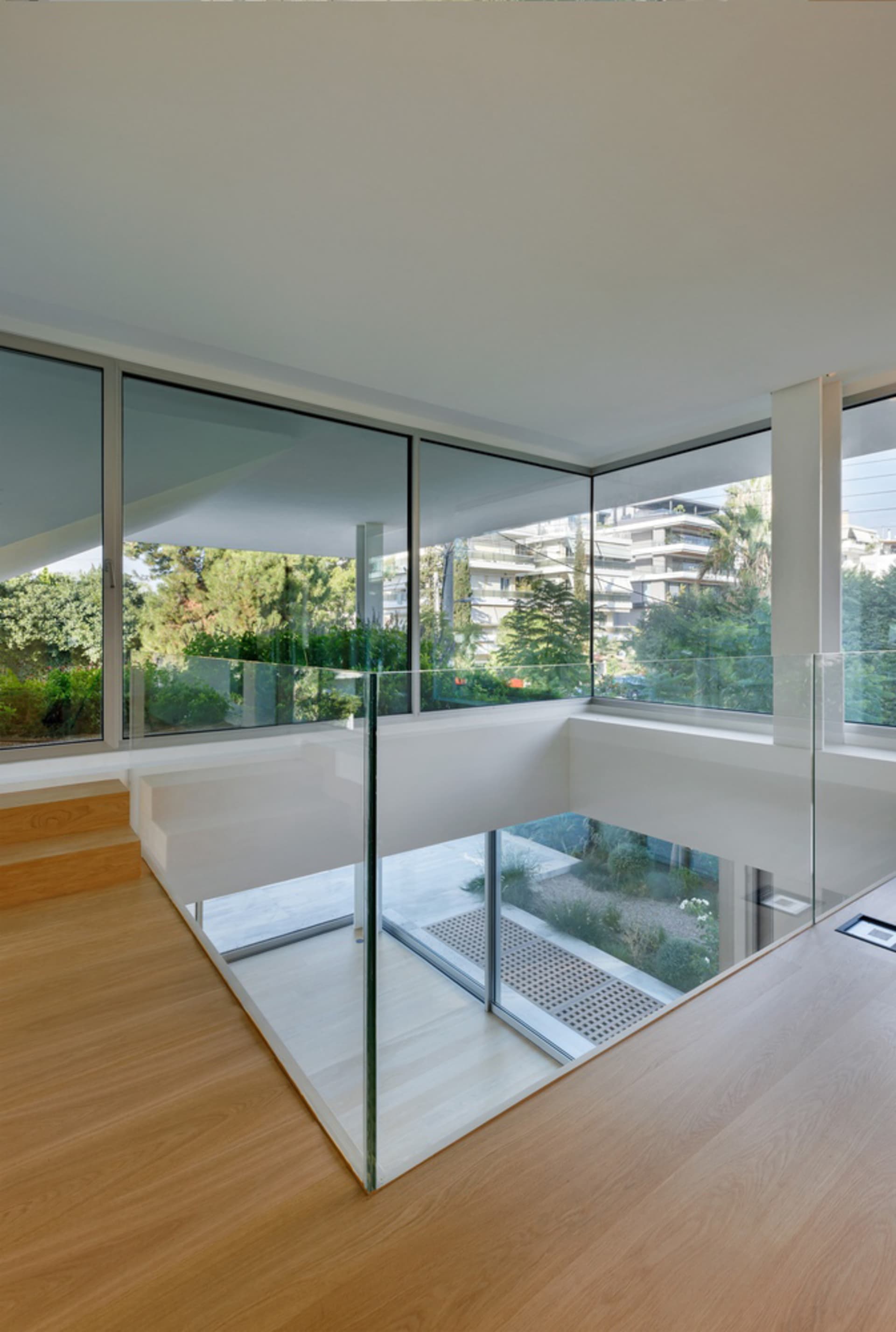 Modern architectural design featuring a glass staircase with wood flooring.