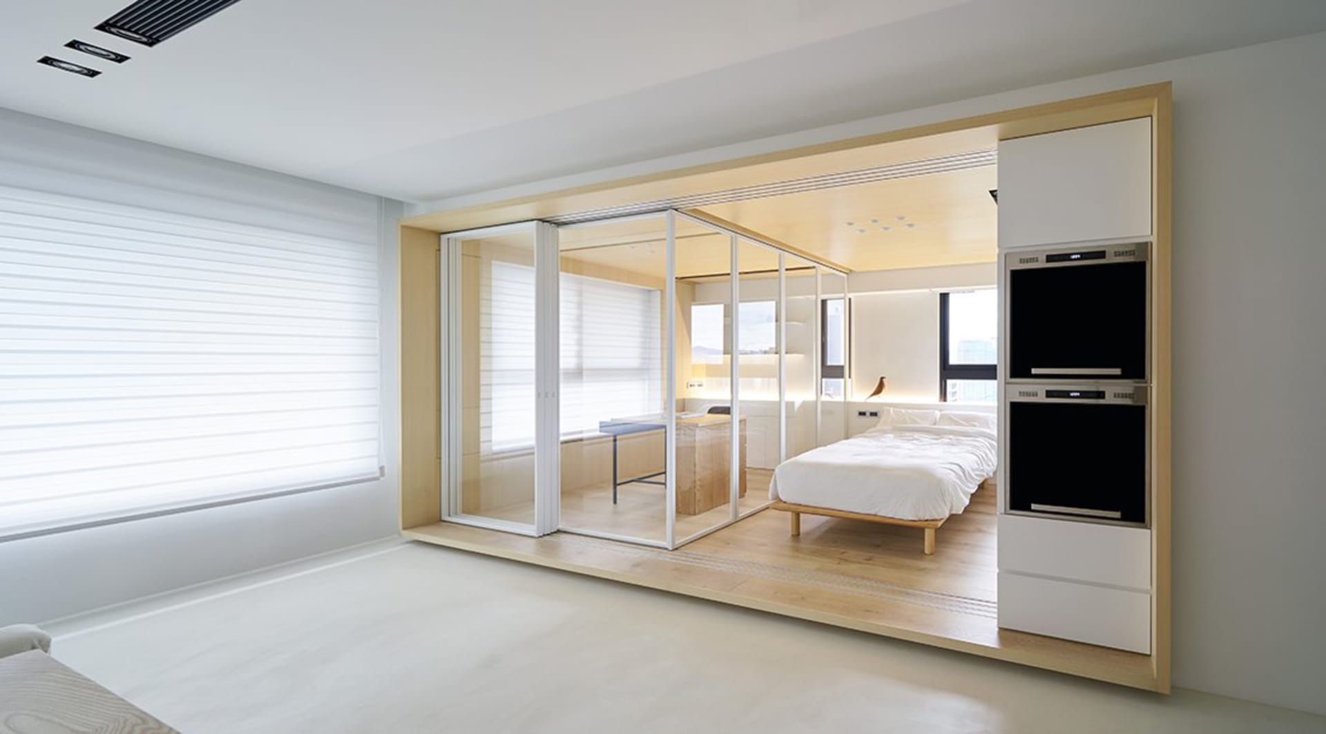 A modern bedroom featuring white walls, glass walls, and a wood frame.