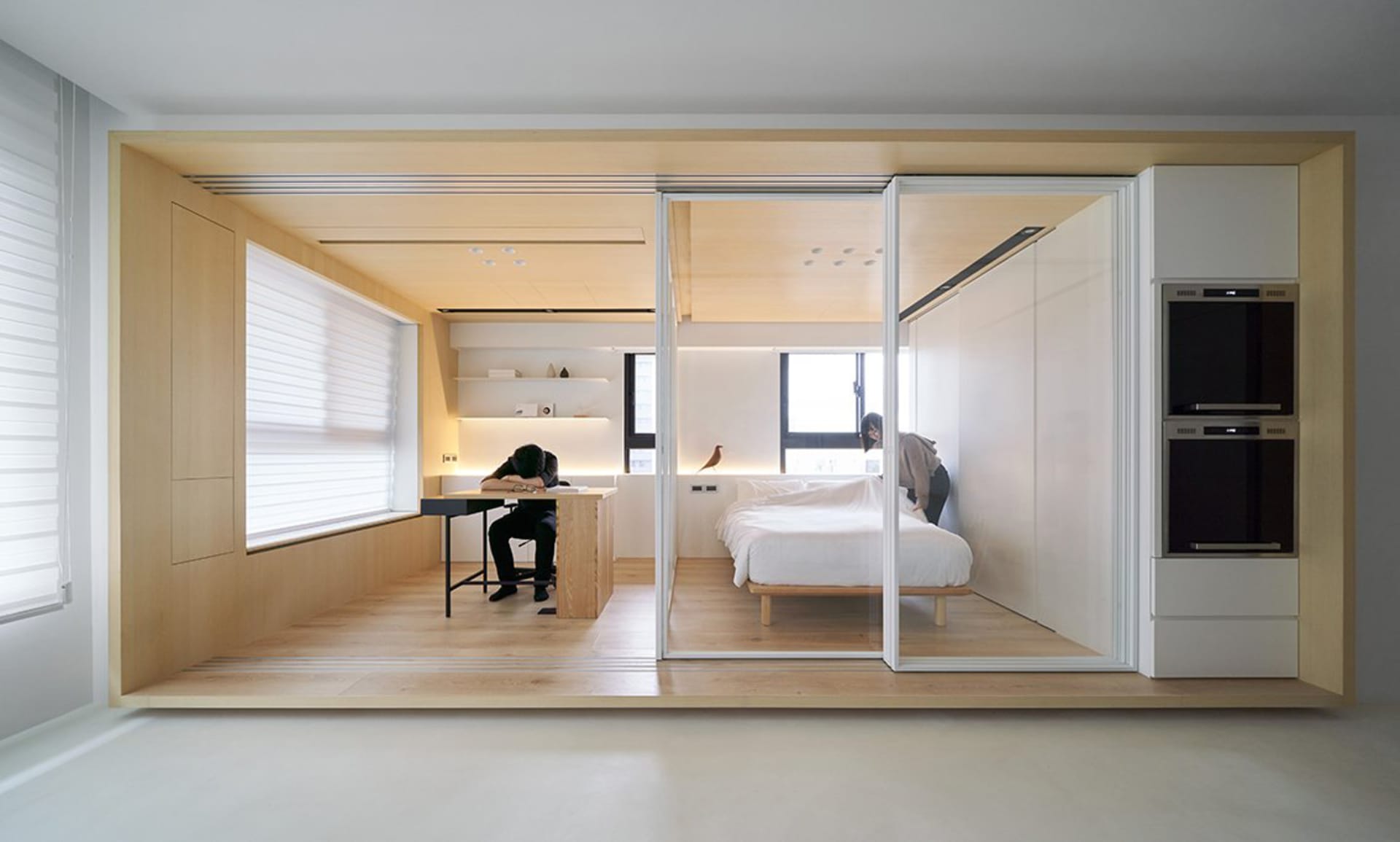 A minimalist apartment with white walls, natural pine, and modern lighting features.