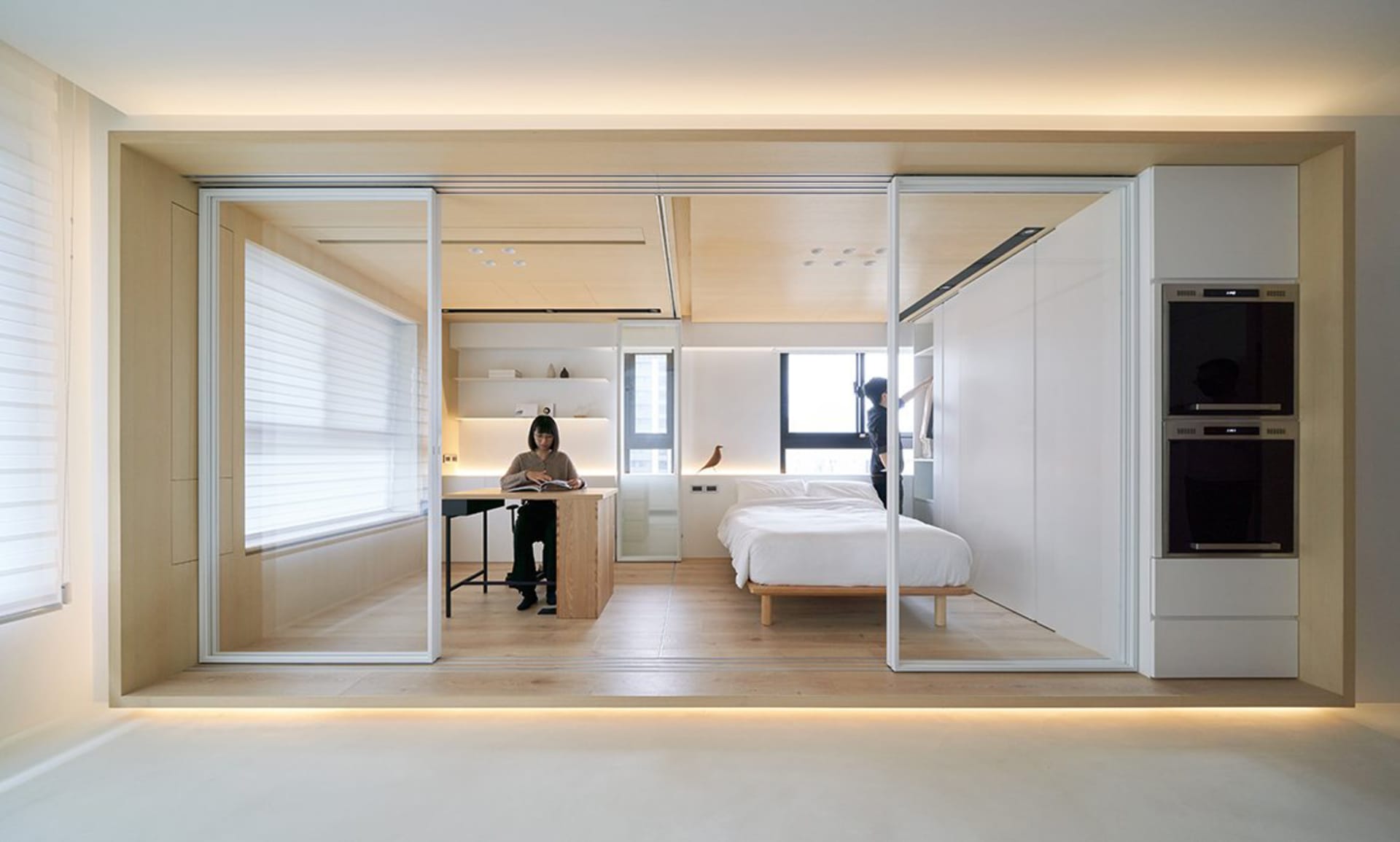 A minimalist residential space featuring light-colored wood flooring and white walls.