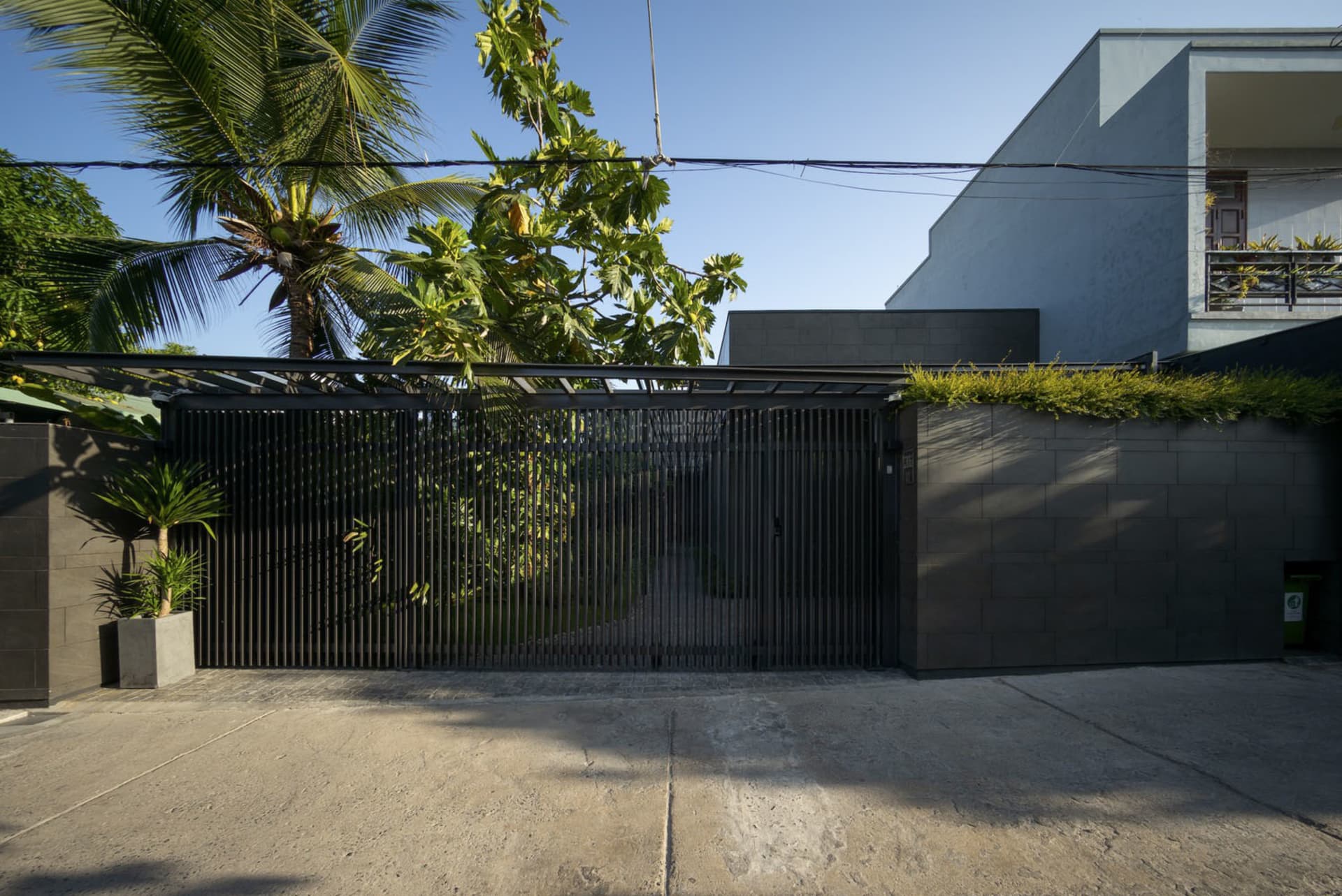 Modern design black metal security gate with concrete slabs.