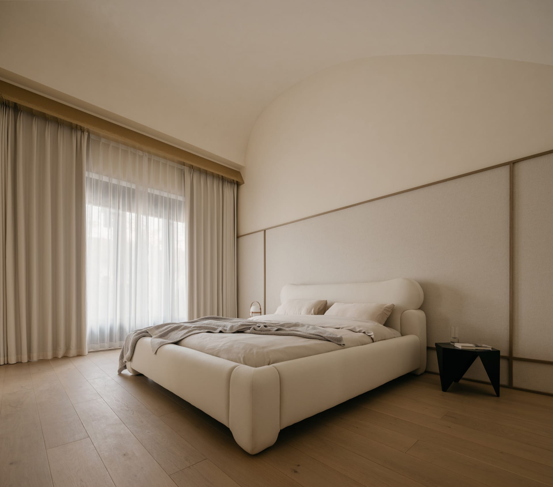 A minimalist bedroom with a neutral-toned bed featuring soft textiles and a modern side table.
