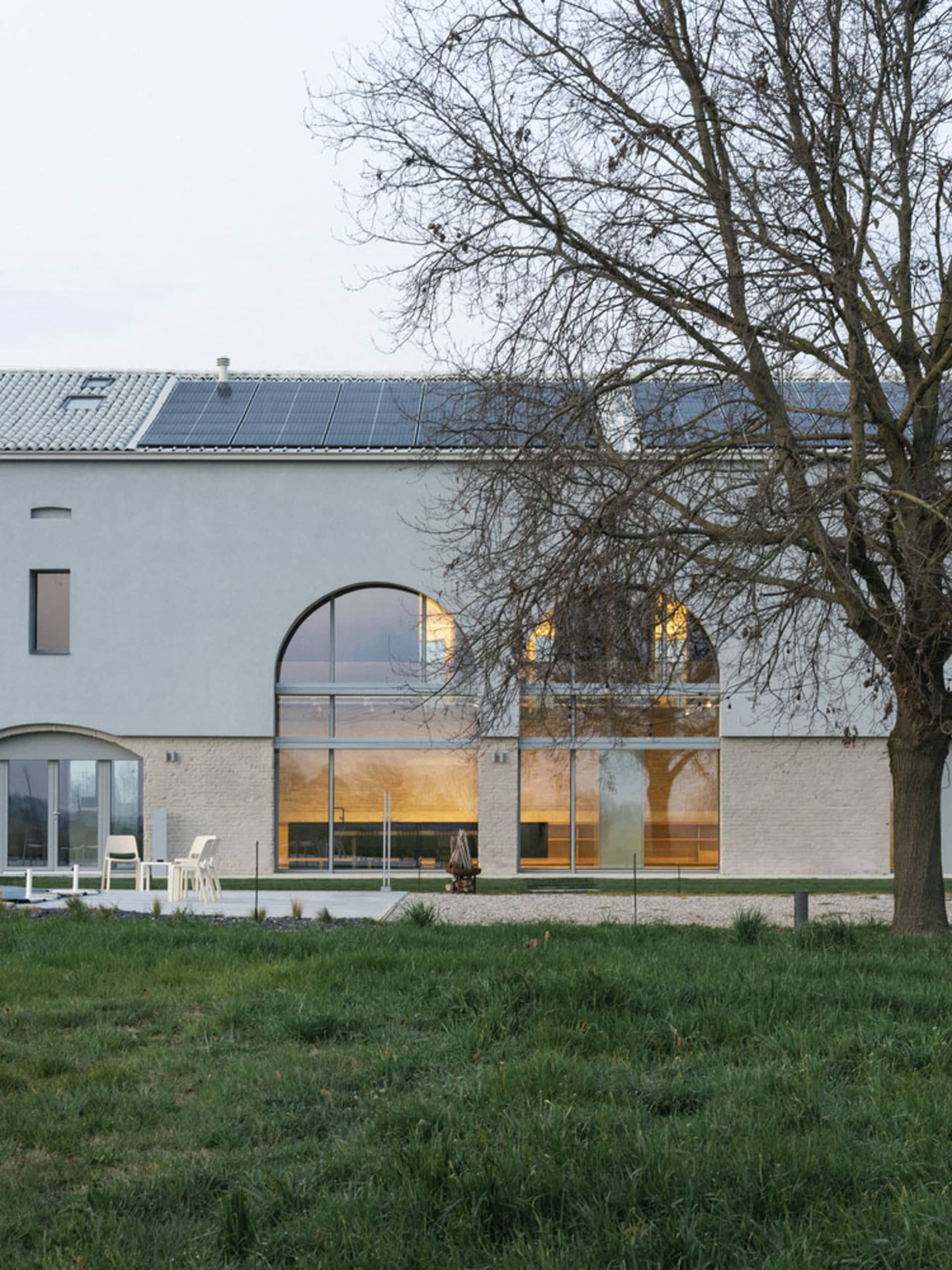 A modern house exterior featuring large glass windows
