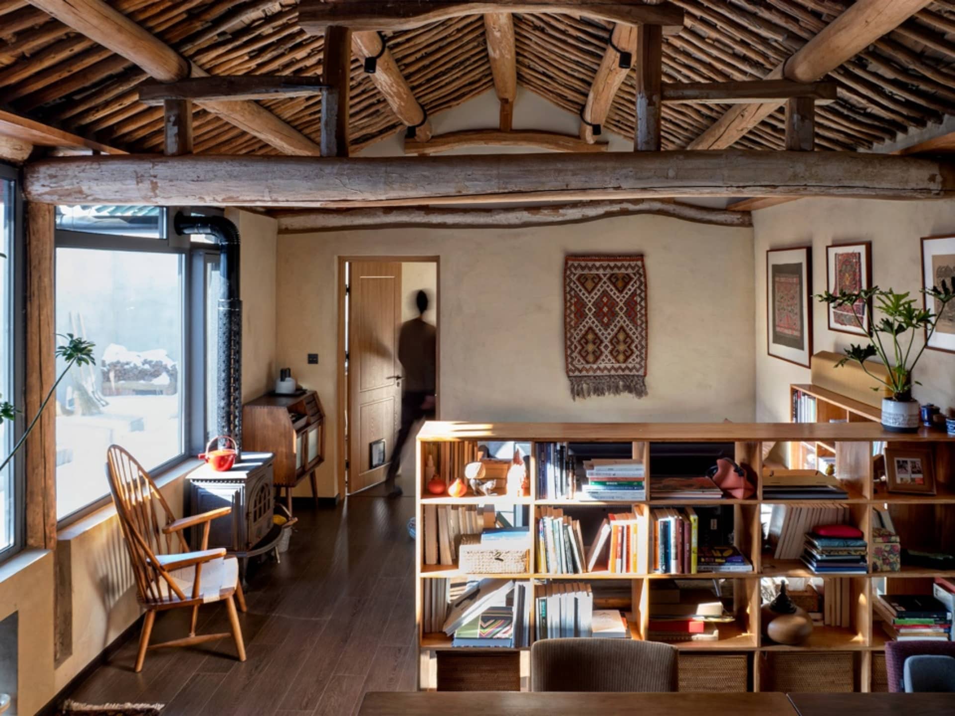 Industrial-themed living room featuring wooden walls and a bookshelf.