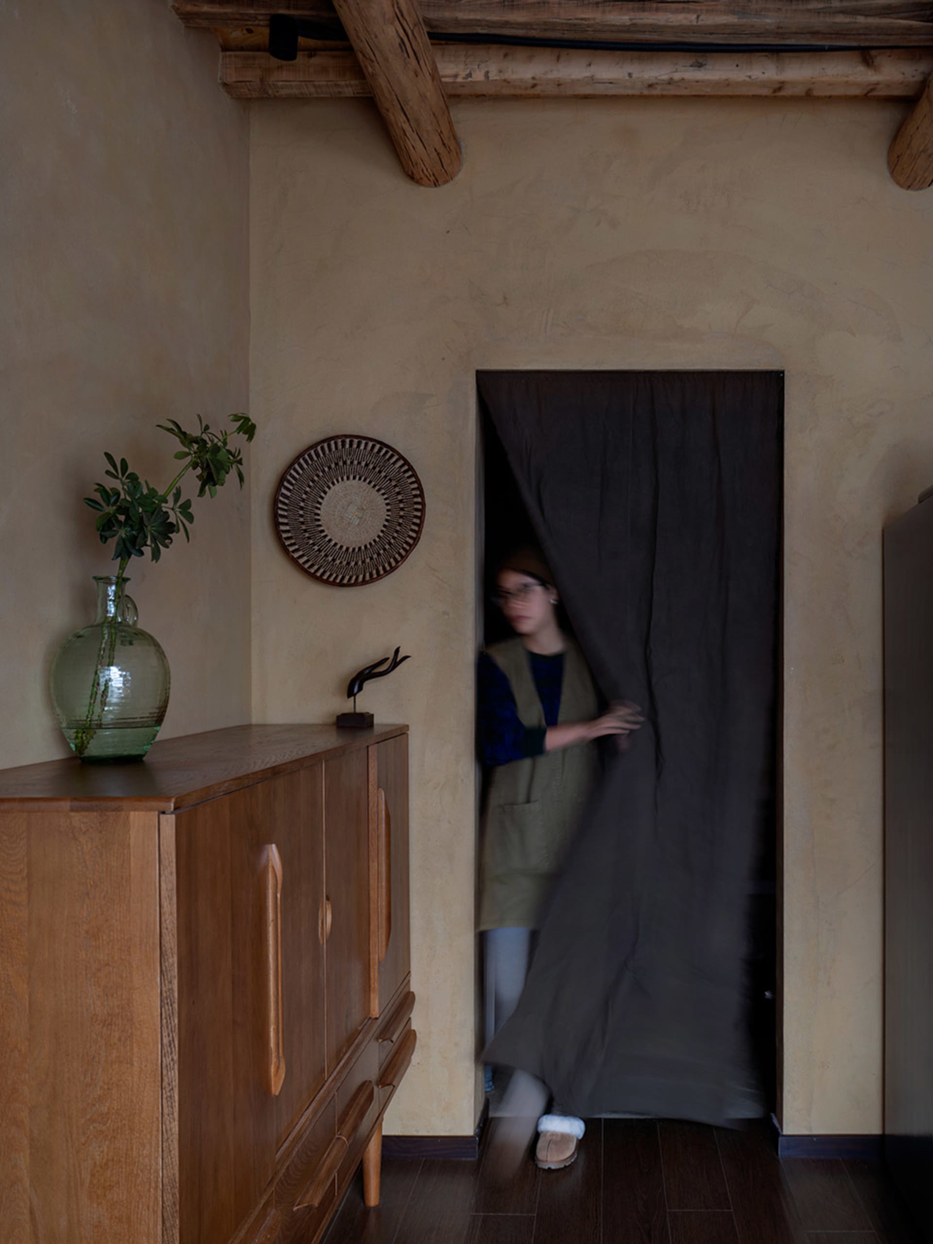 A photograph of an industrial residential interior showcasing a doorway with a curtain.