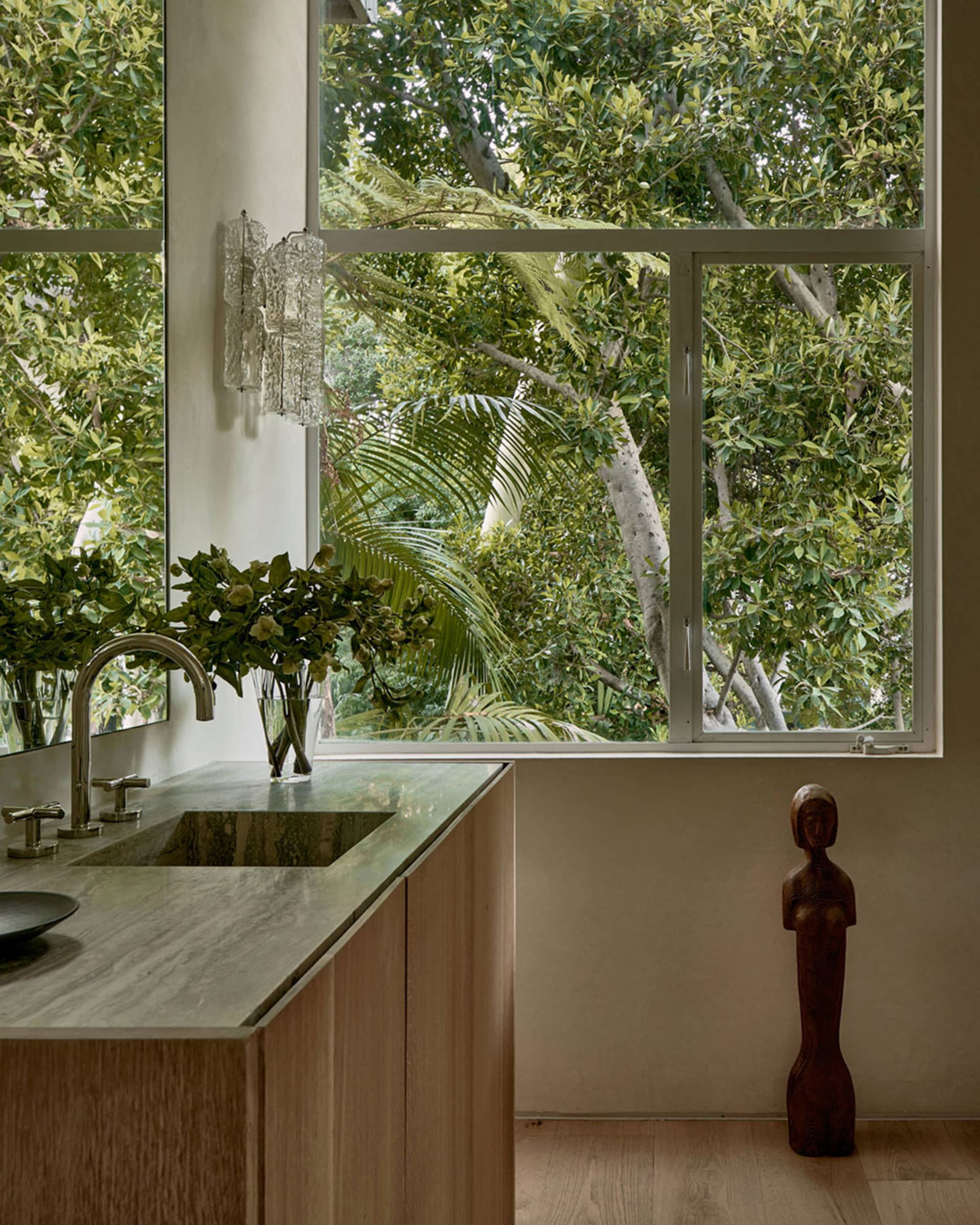 Modern kitchen with marble countertop, wooden furniture, and glass shelving