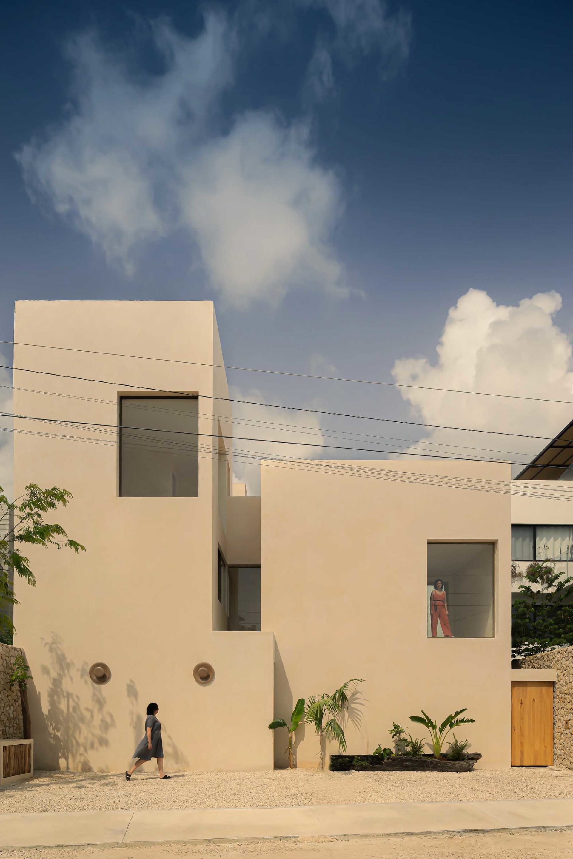 A minimalist house with a concrete exterior and large windows.