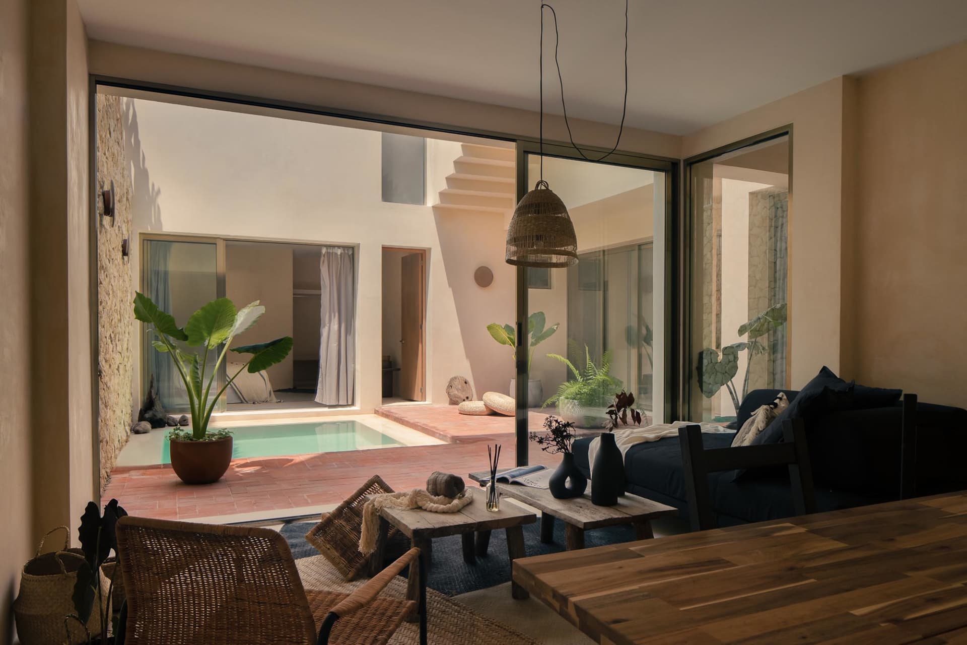 Modern living room with wood furniture, stone walls, and glass doors.
