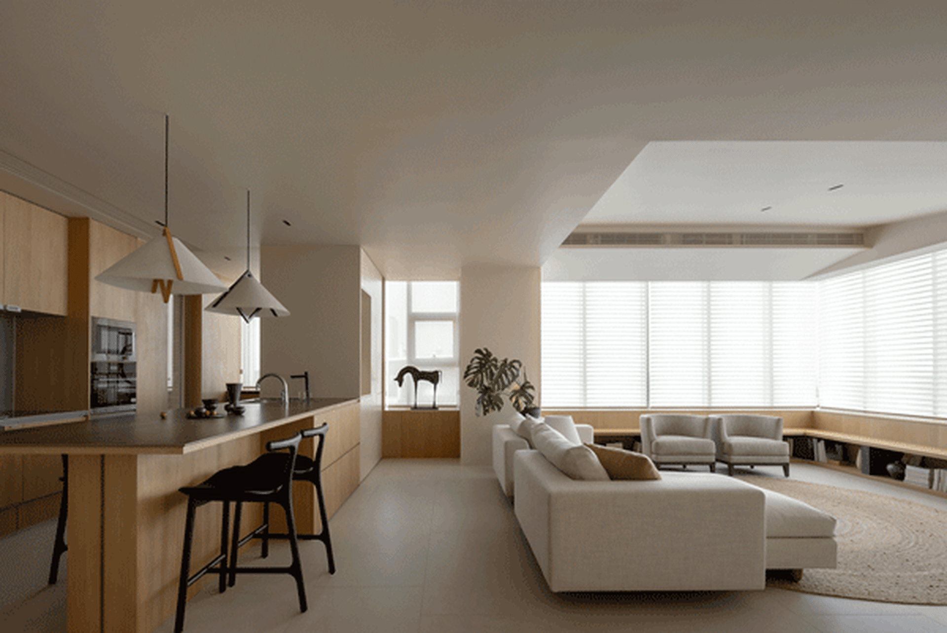 A modern living room featuring a white sofa, concrete flooring, and a large window with blinds.