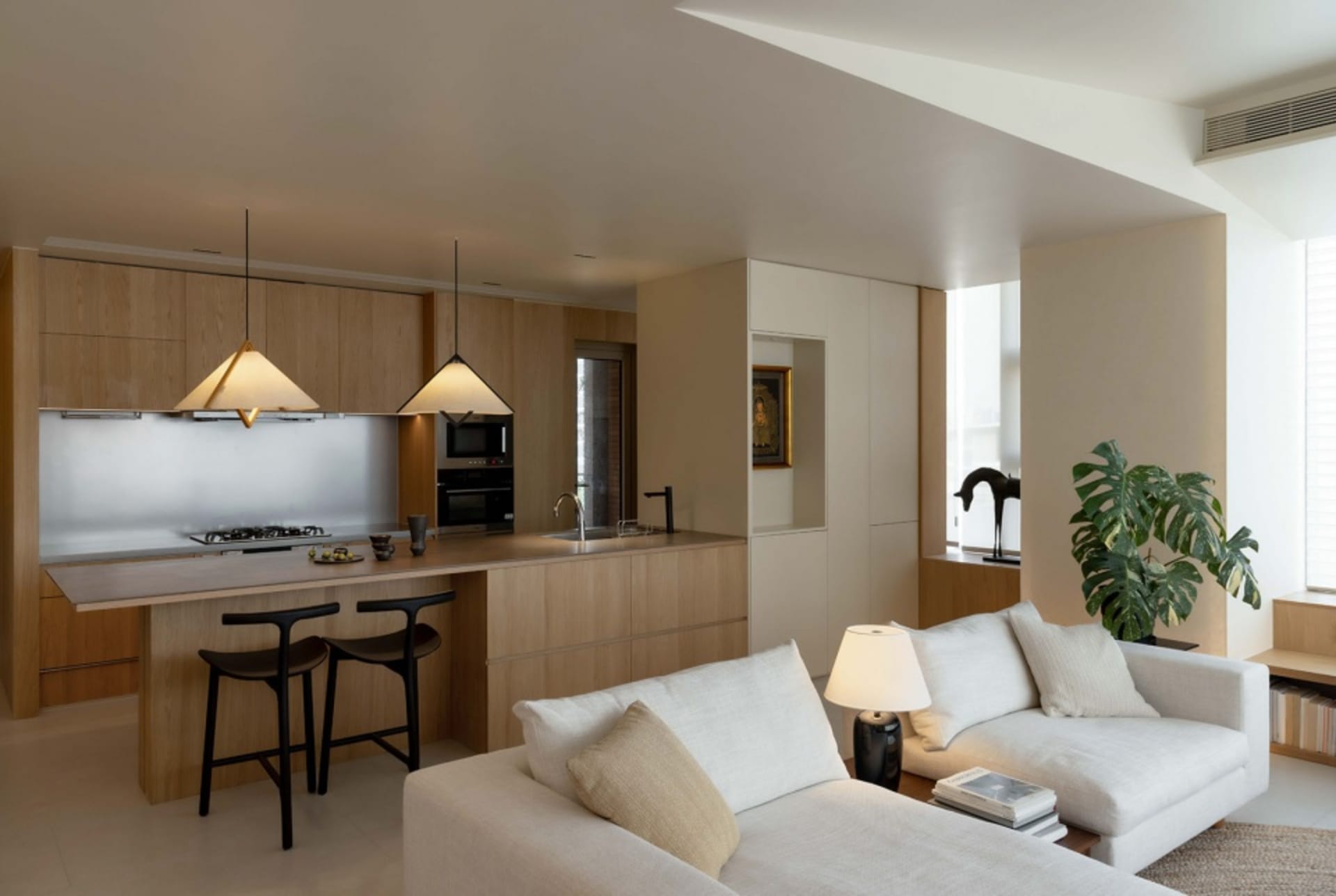 Modern living room and kitchen with wooden cabinets, metal kitchen island, and minimalistic design elements.