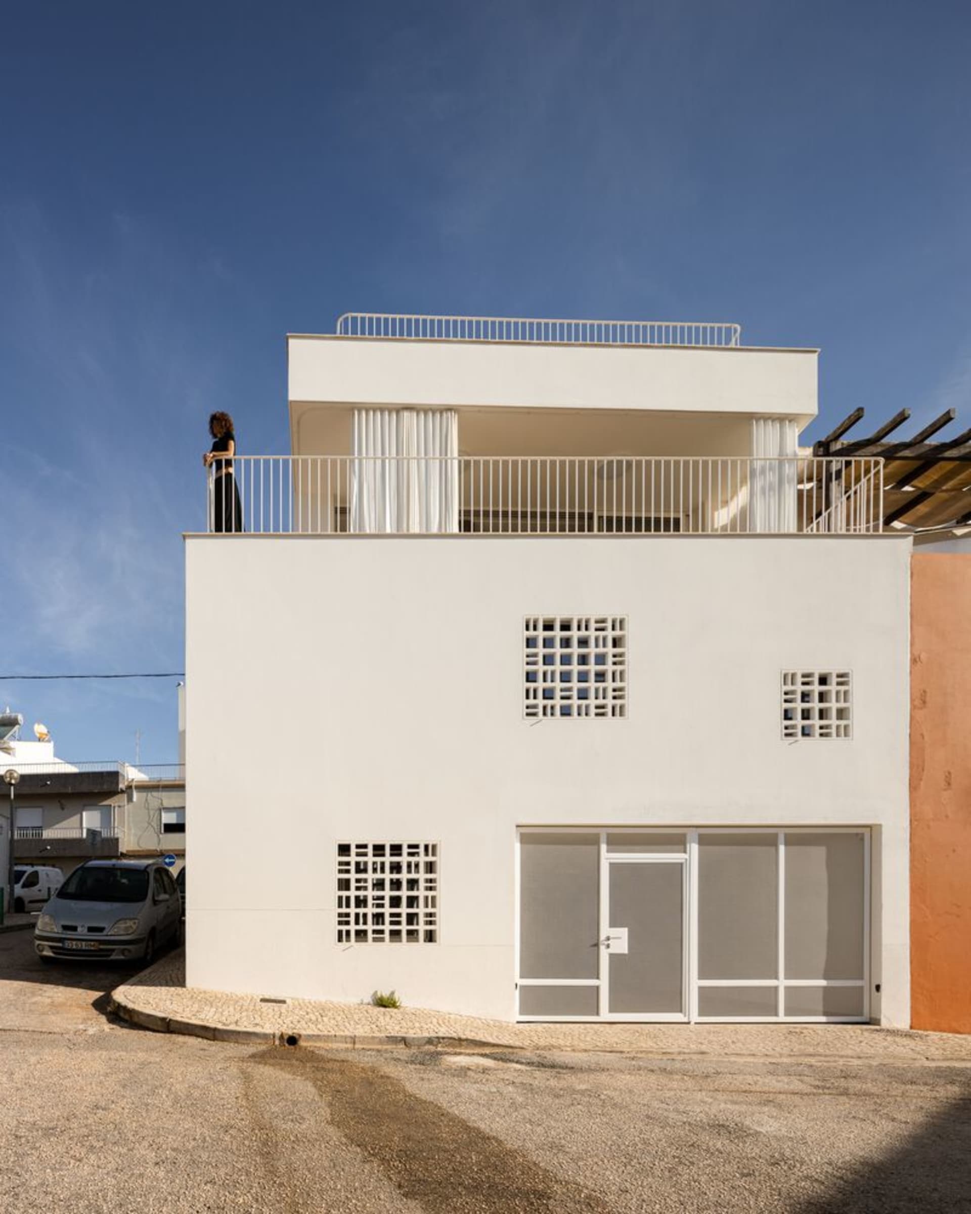 Modern building with white plaster exterior and glass windows.