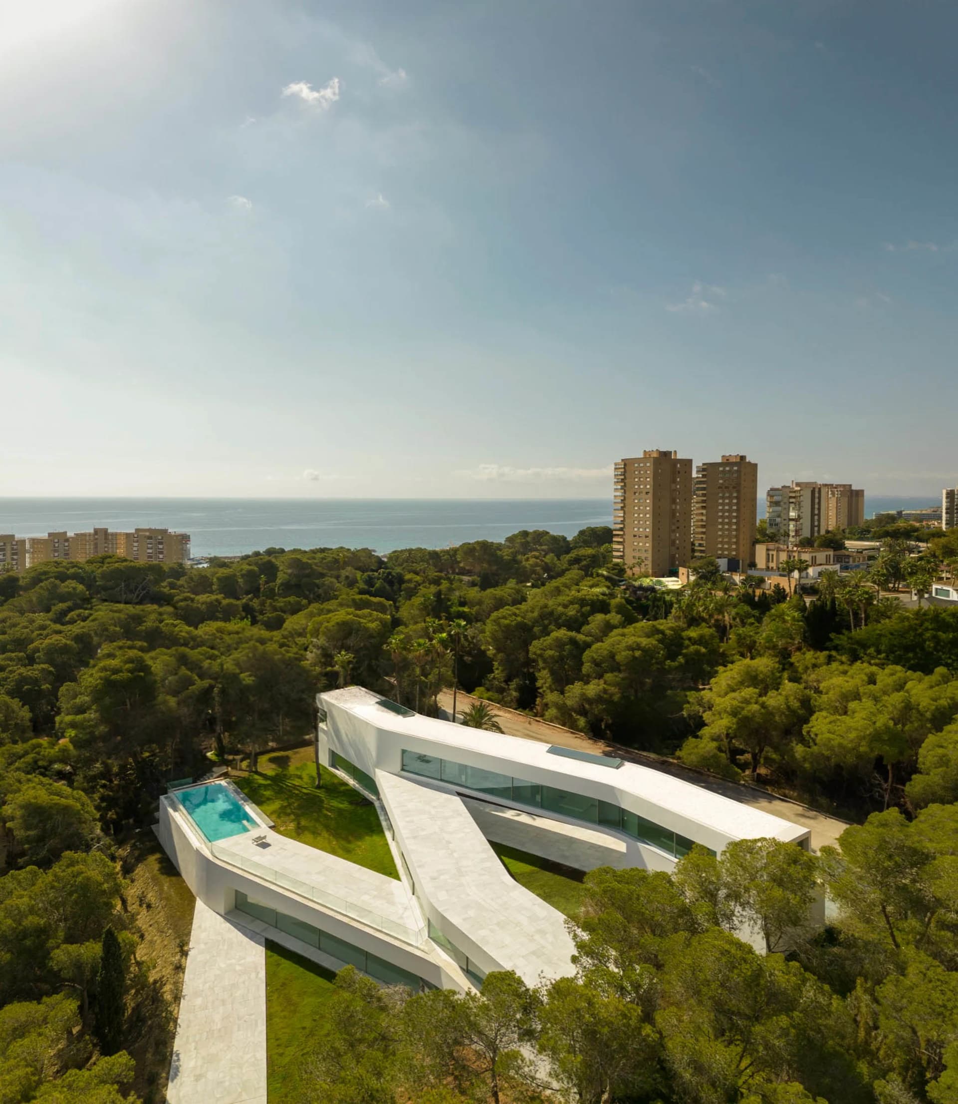 A modern residential villa featuring glass walls and concrete floors.