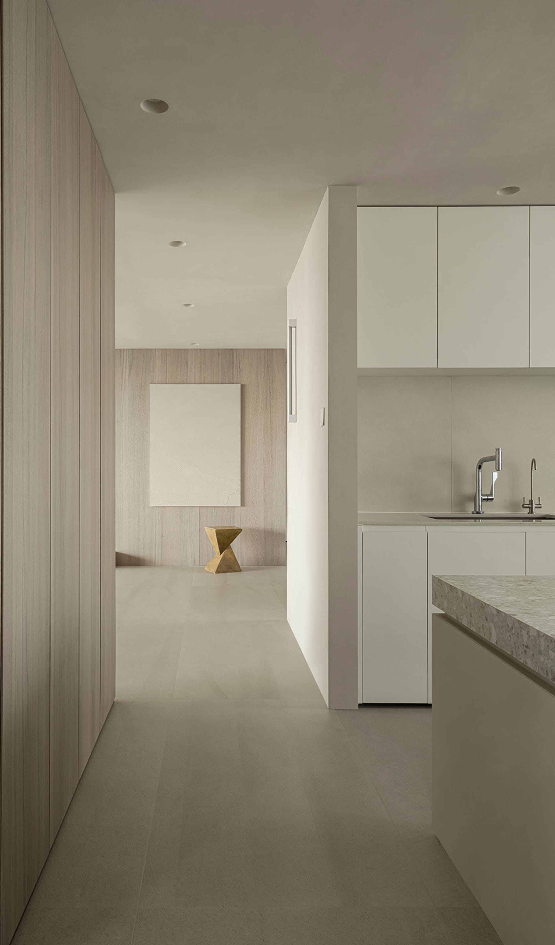 Modern minimalist kitchen with concrete flooring, white cabinets, and a minimalist light fixture.
