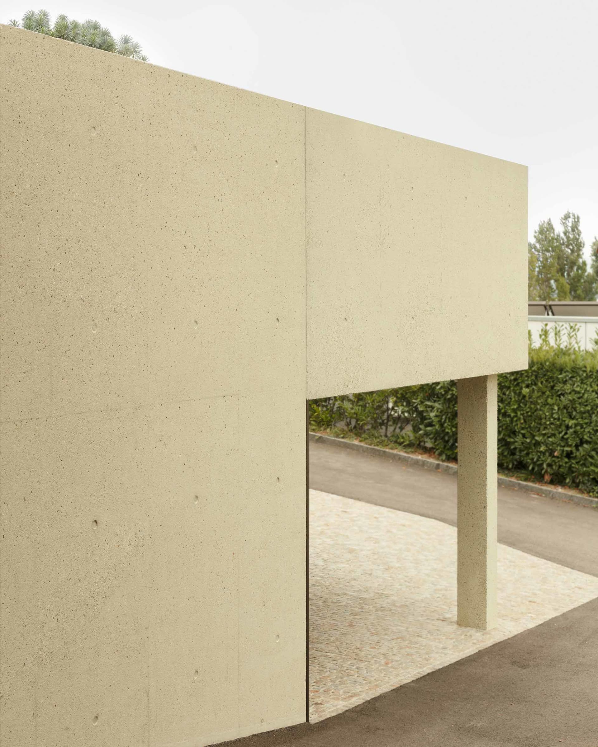 Minimalist building exterior constructed of concrete, featuring clean lines and a flat roof.