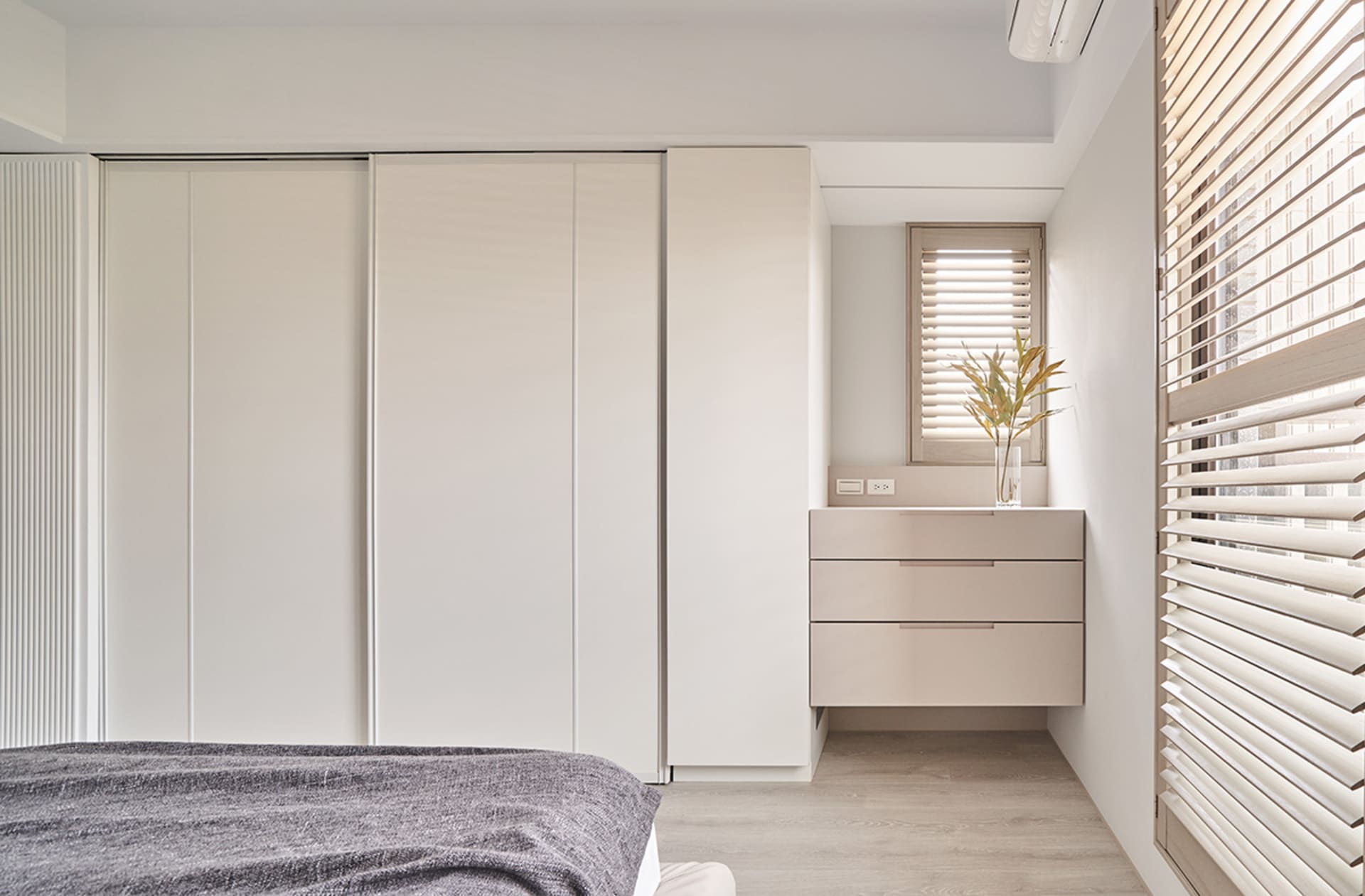 Modern minimalist bedroom featuring wooden furniture and light, neutral color palette