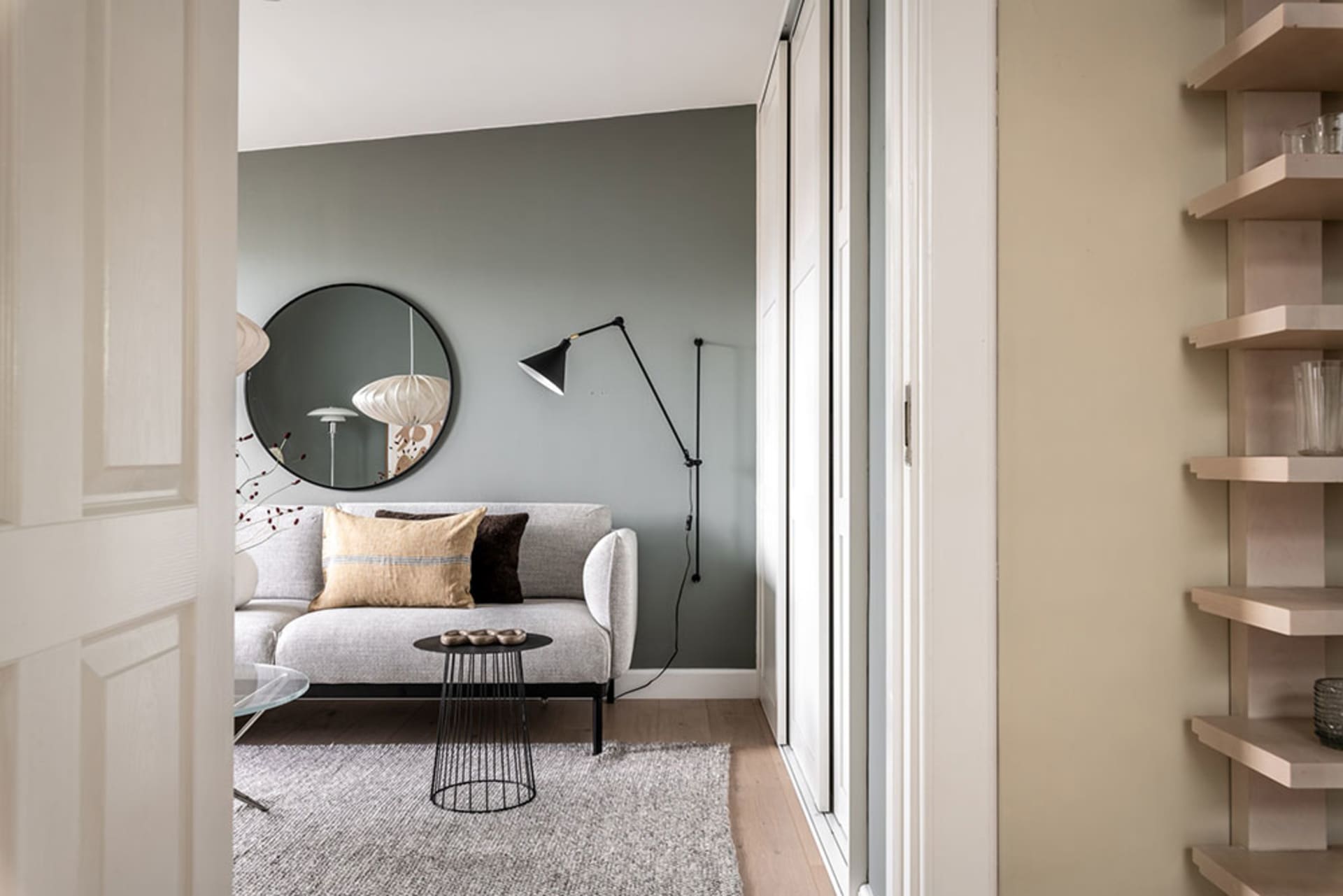 Modern minimalist living room with gray sofa, black and white scandinavian floor lamp, and minimalist coffee table.
