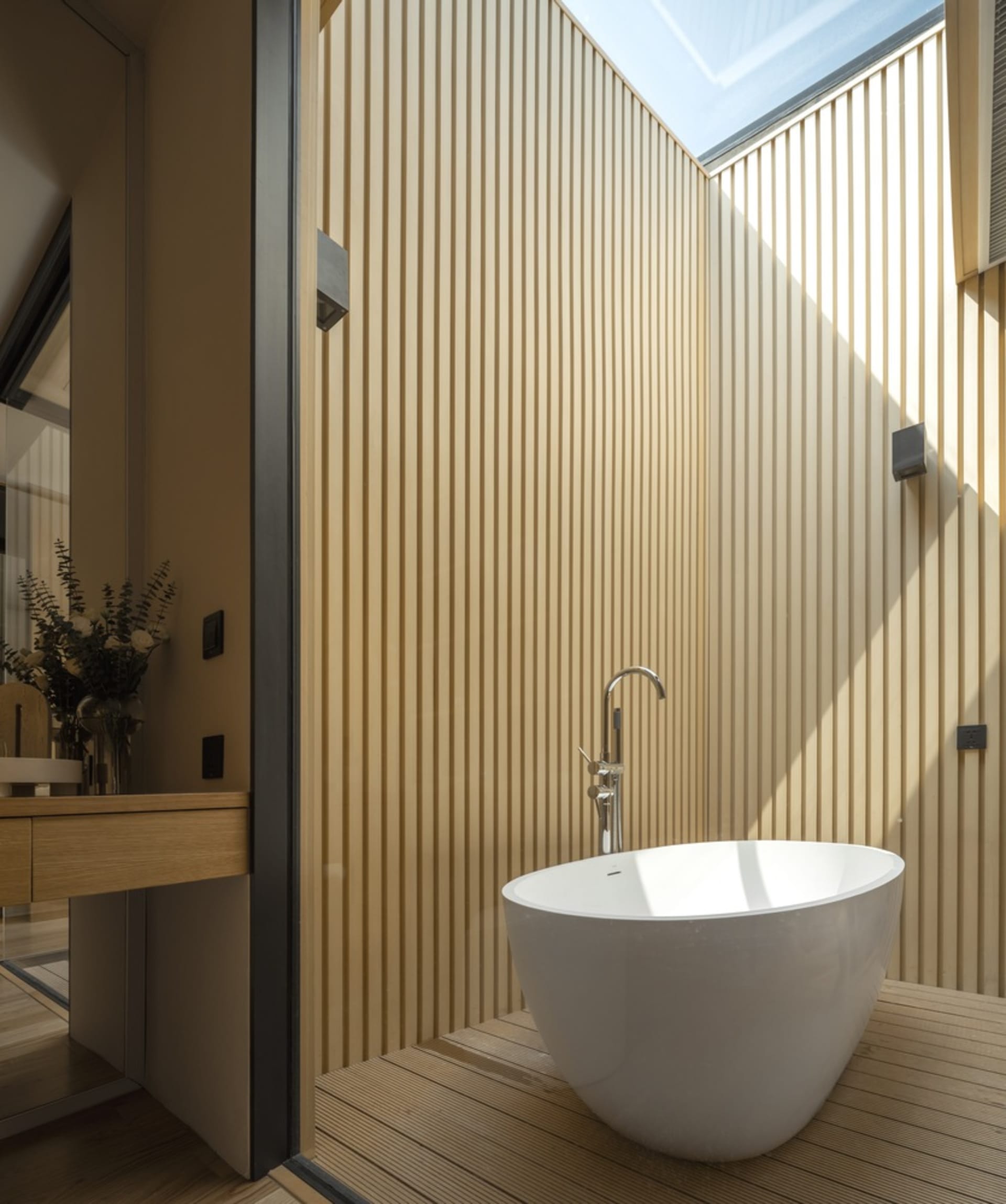 Modern bathroom featuring wooden walls and a white tub