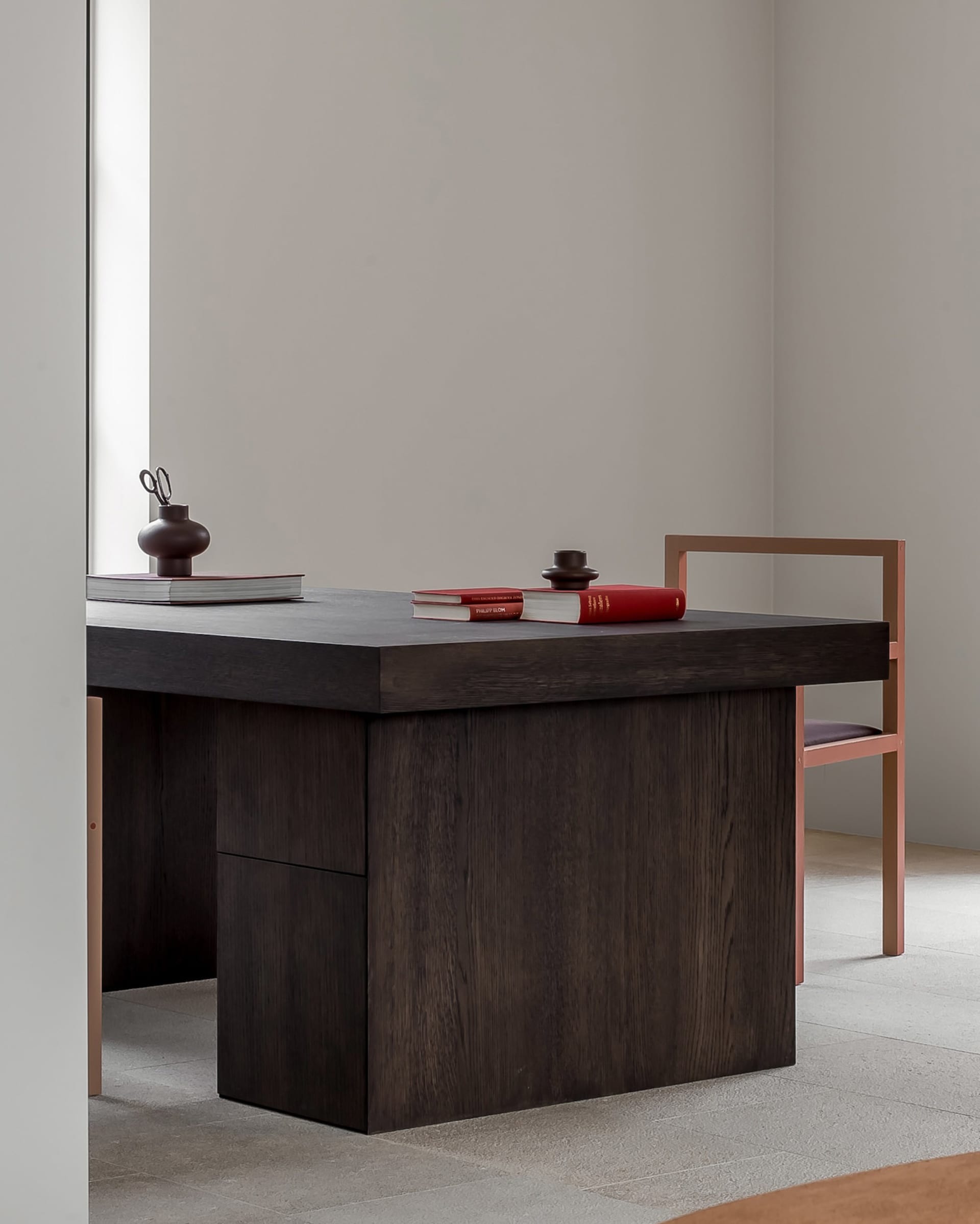 Minimalist modern desk made of dark wood with a copper chair.