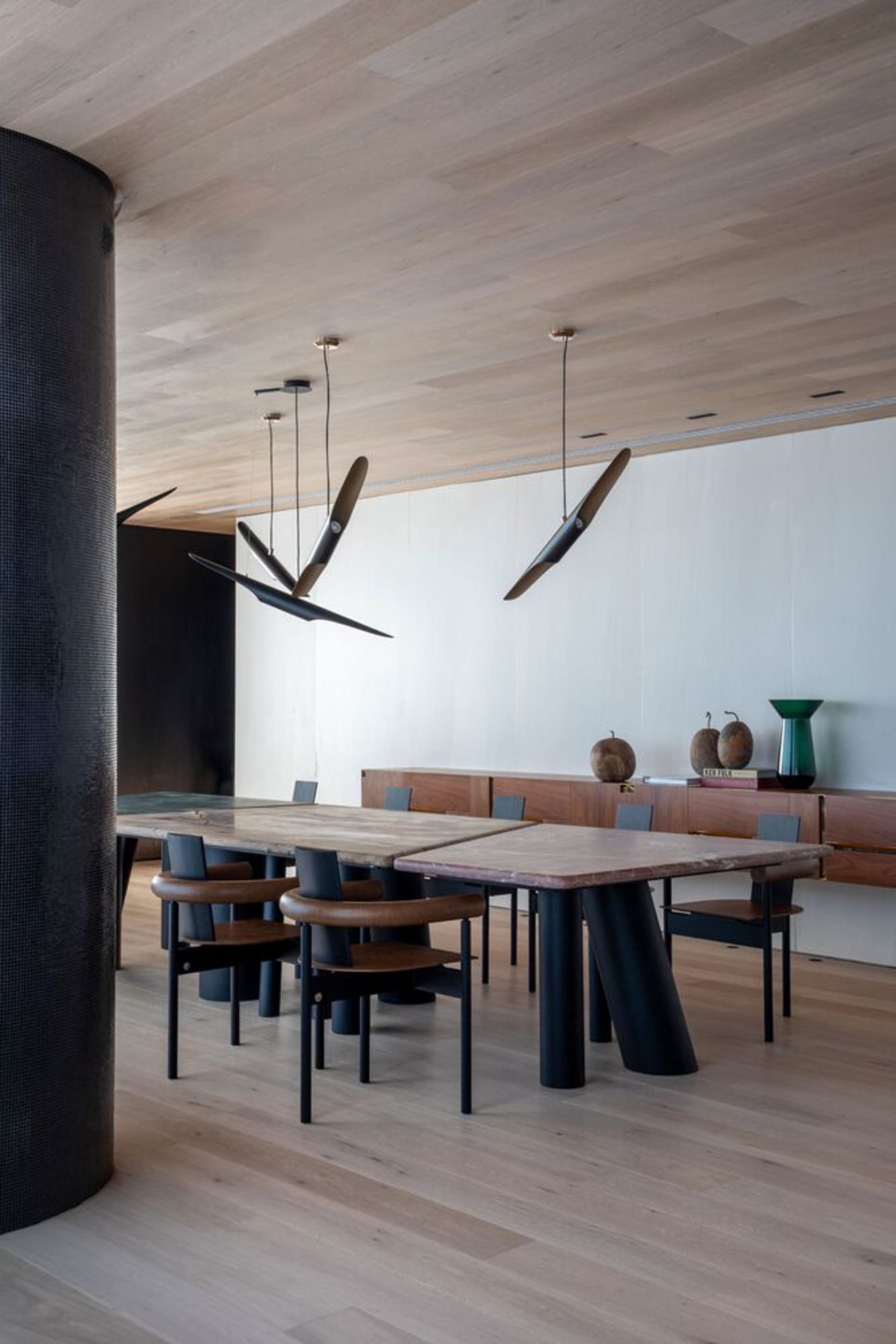 Modern dining room featuring wooden tables, metallic chairs, and leather accents.