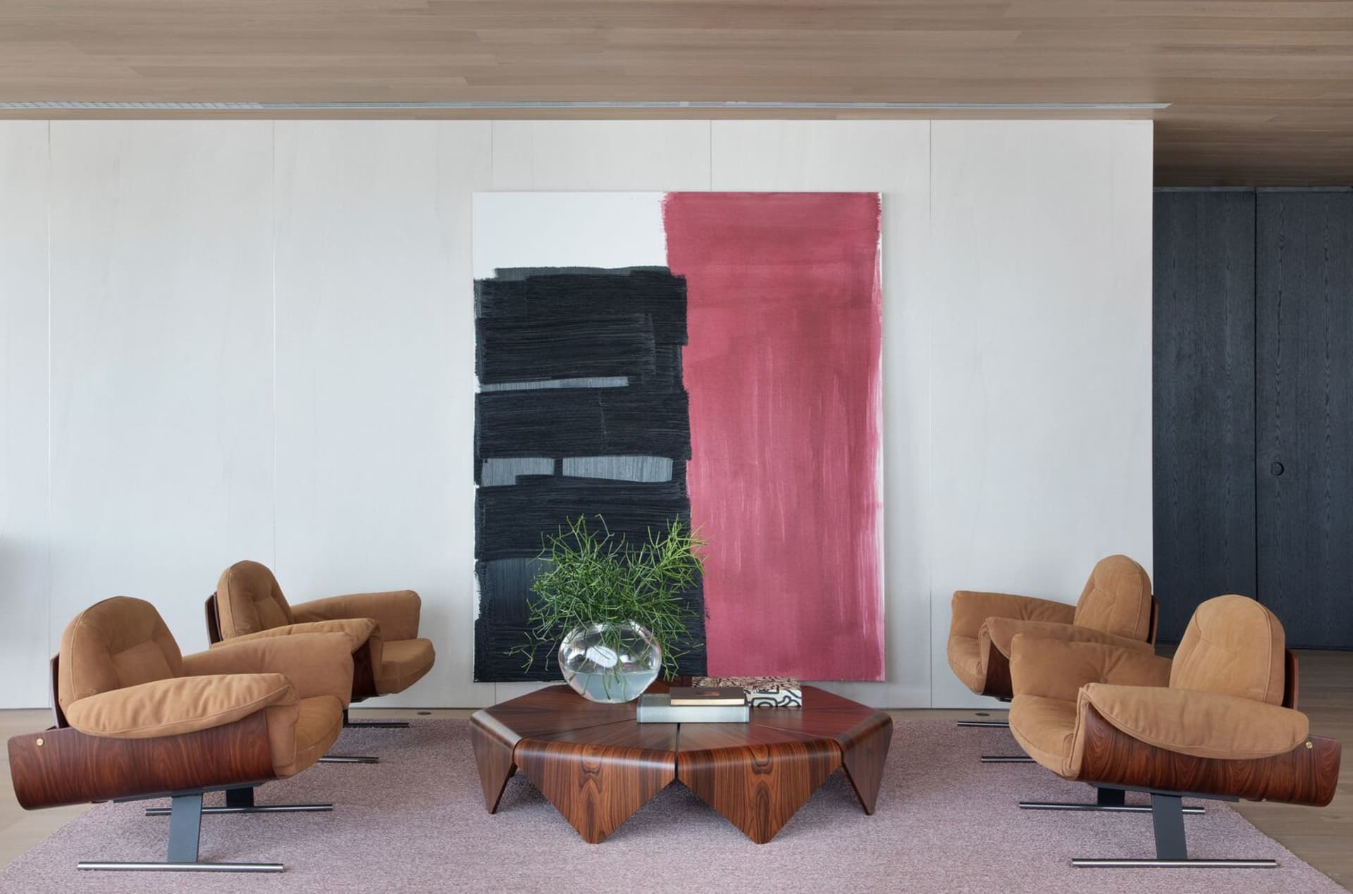 A modern interior living room featuring cozy leather armchairs, a stylish wooden coffee table, and a striking abstract painti