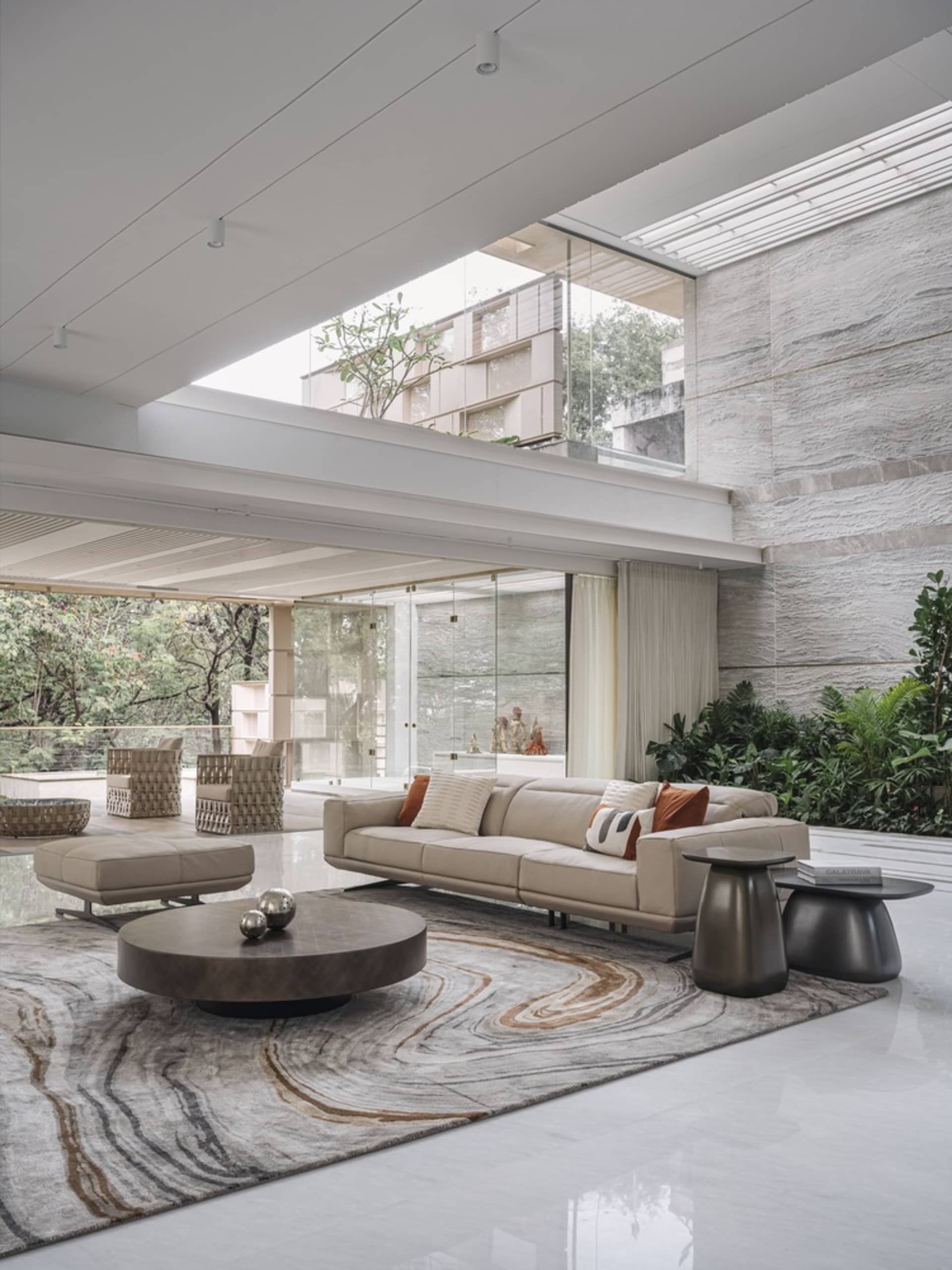 Modern minimalist living room with concrete walls, wood accents, and marble floor.