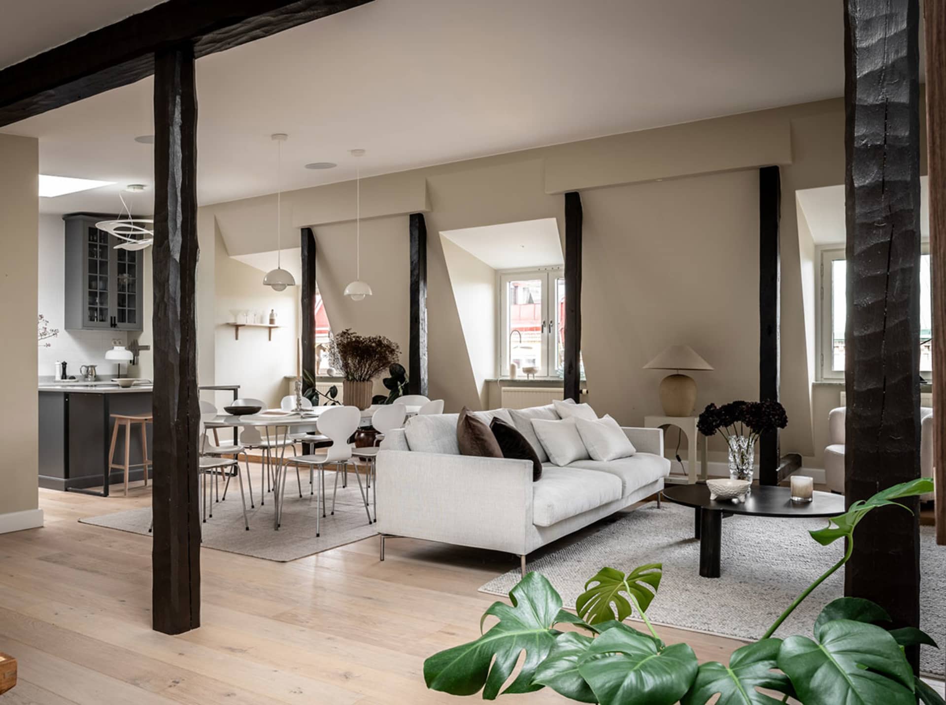 Modern minimalist living room with wood flooring, concrete accents, and contemporary furniture.