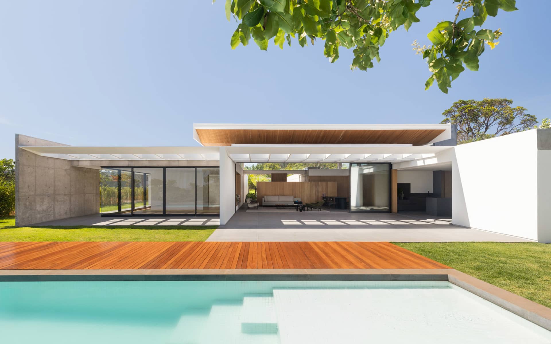 Modern residential exterior featuring concrete, glass, and wood materials.