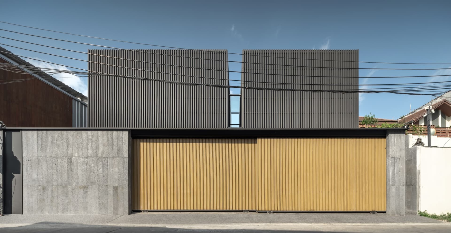 Modern residential facade featuring metal siding and wood panels.