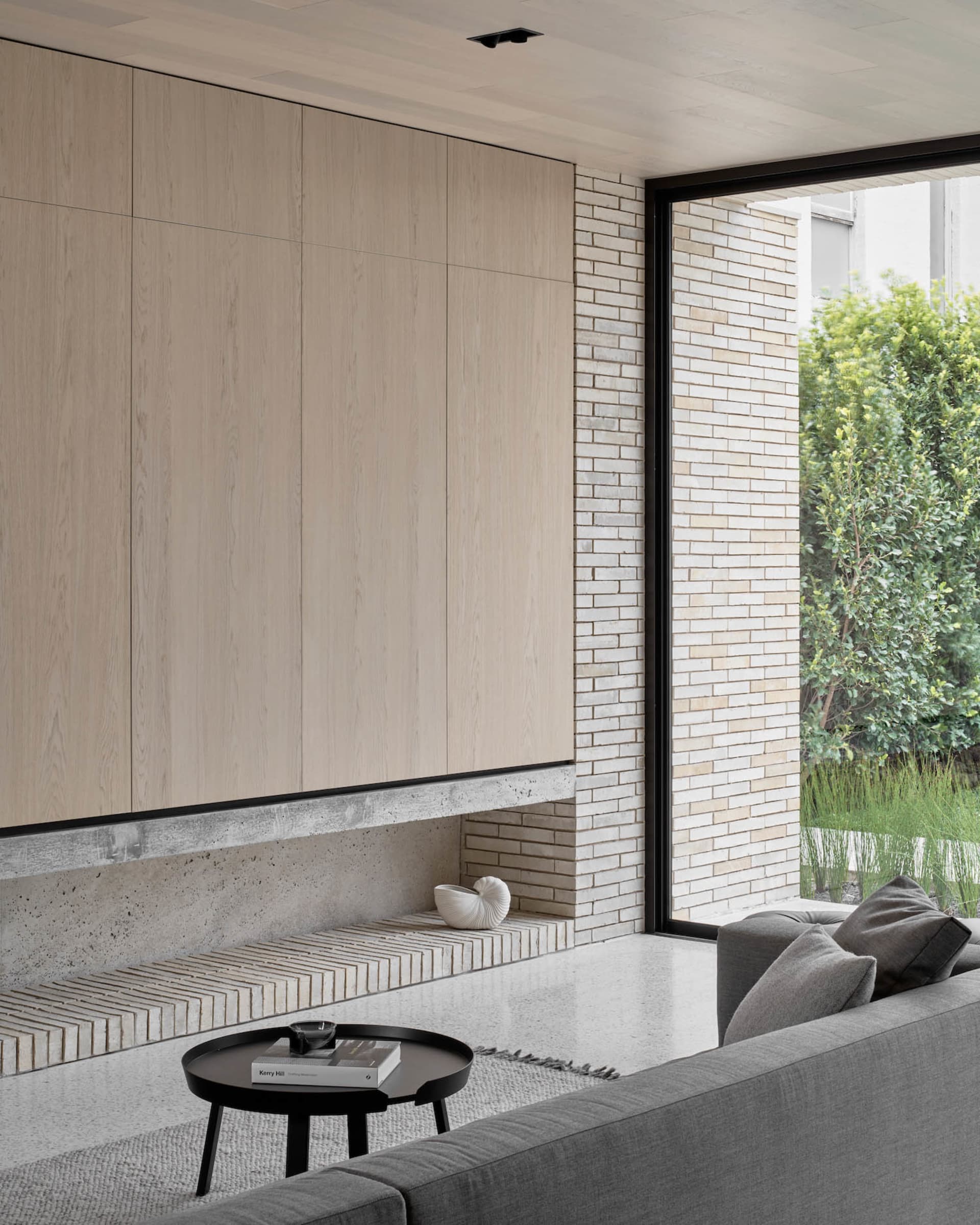 A modern living room featuring concrete, brick, and wood materials