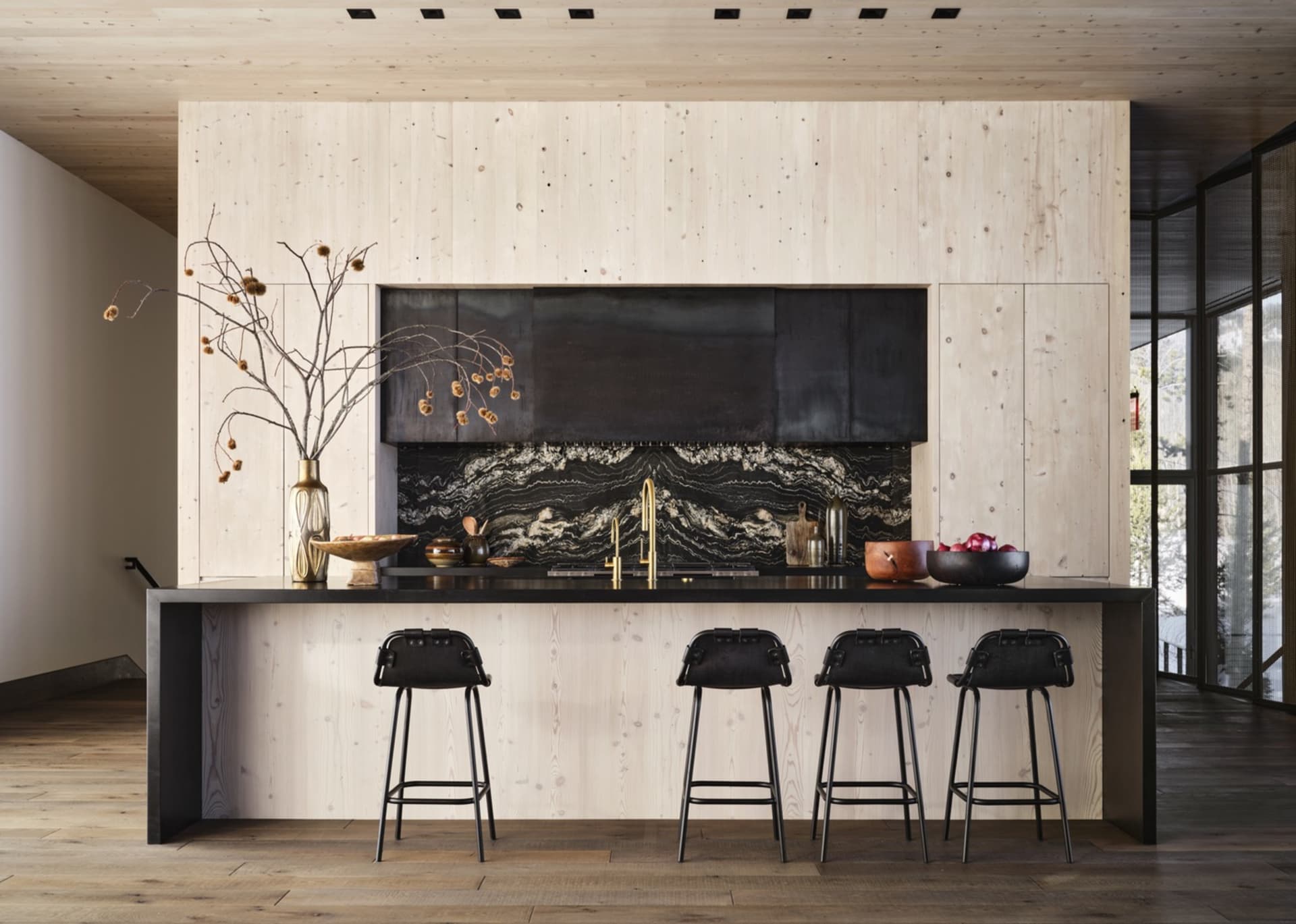 A modern residential kitchen with wood cabinets and black granite countertops.