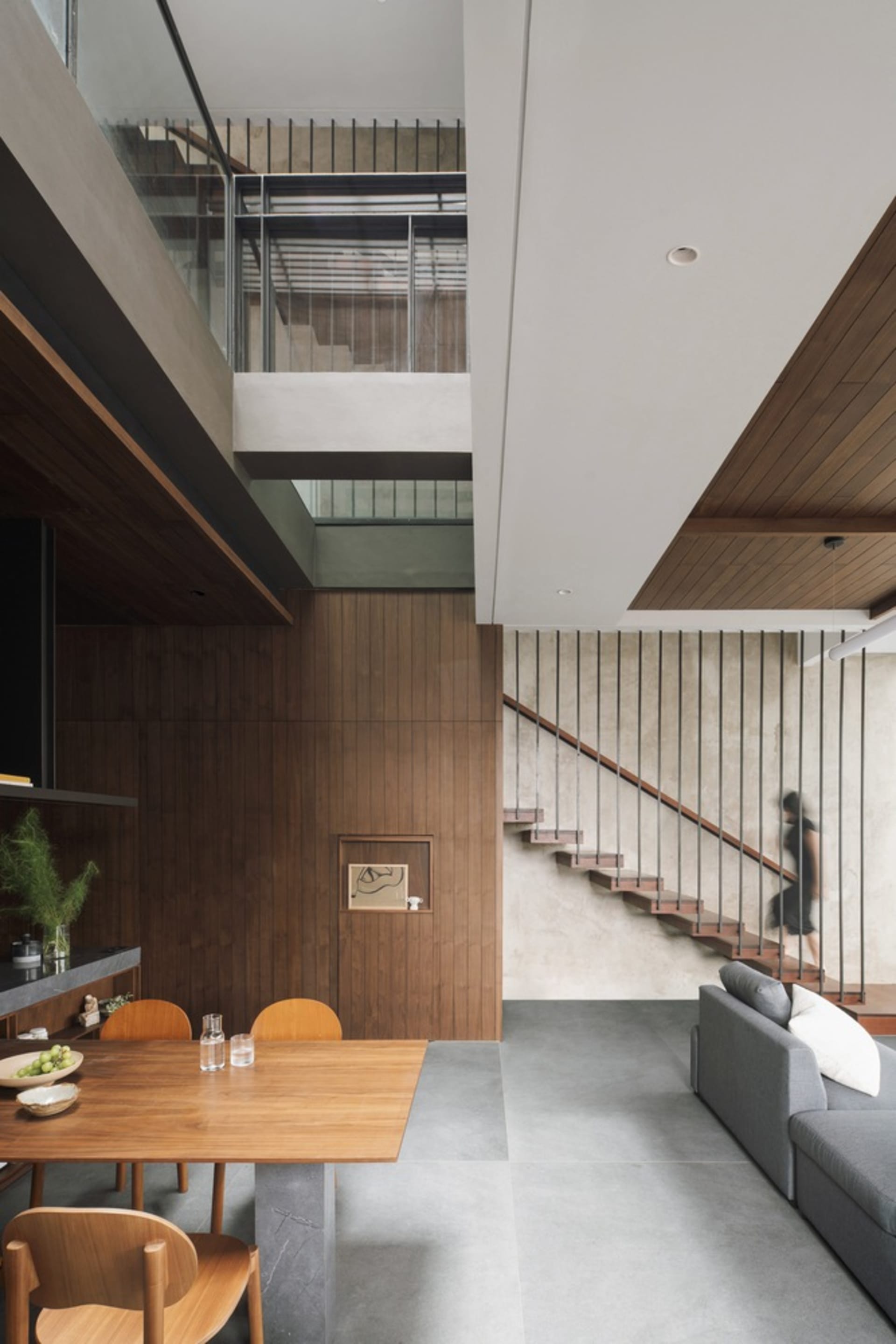 Modern residential interior with wooden furnishings, concrete flooring, and minimalist design features.