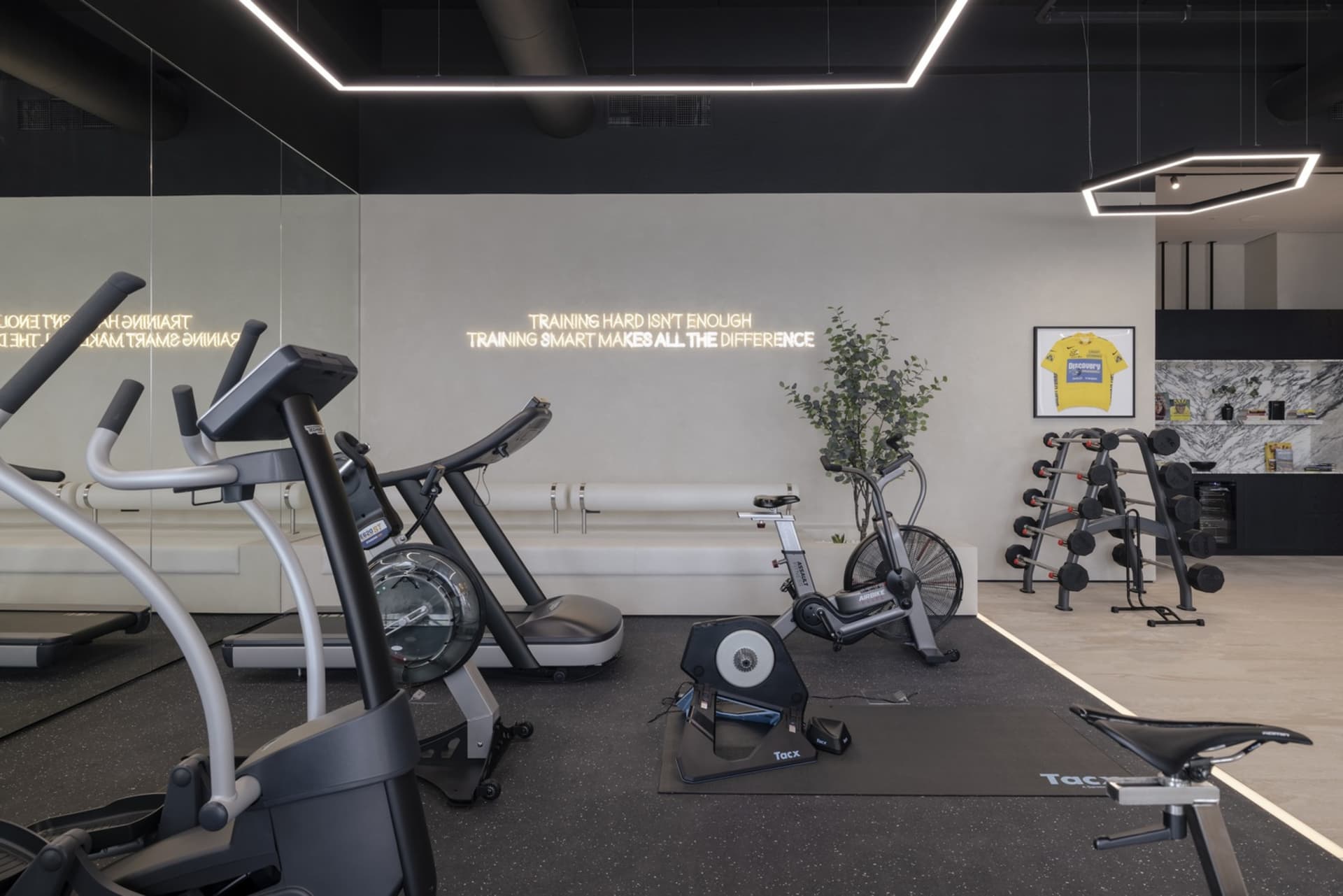 Modern gym with minimalist design featuring metal, glass, and wooden elements.